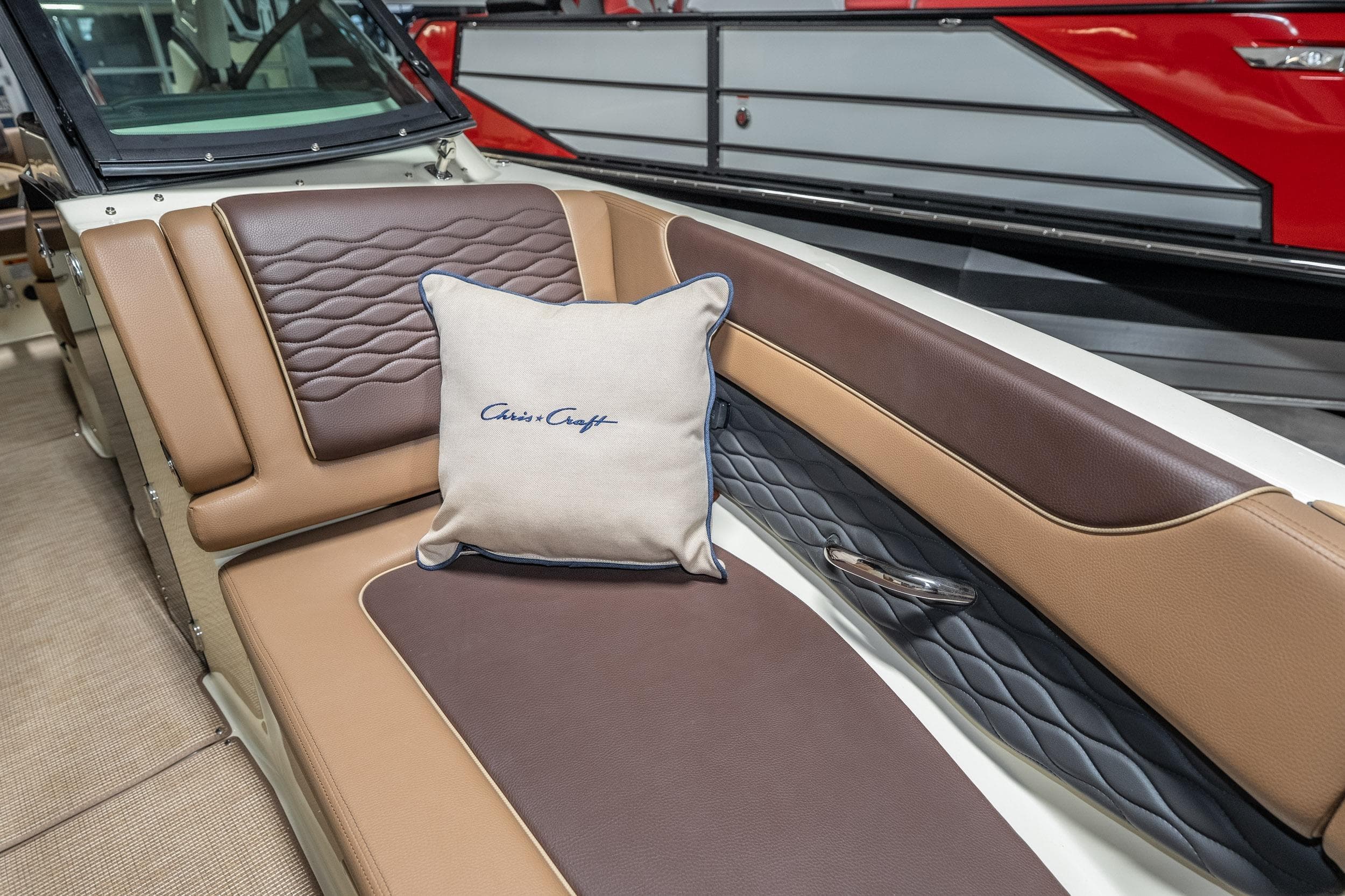 2026 Chris-Craft Sportster 28 interior with luxurious brown leather seating and branded cushion.