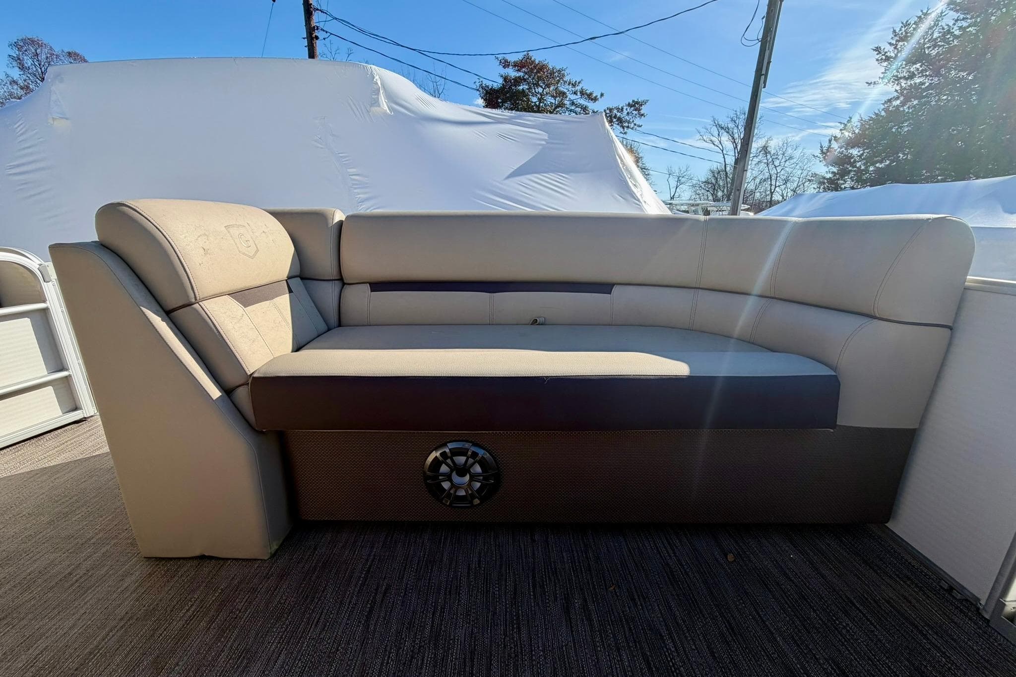 2023 Godfrey Sweetwater 2286 SFL boat interior with beige seating and speaker.