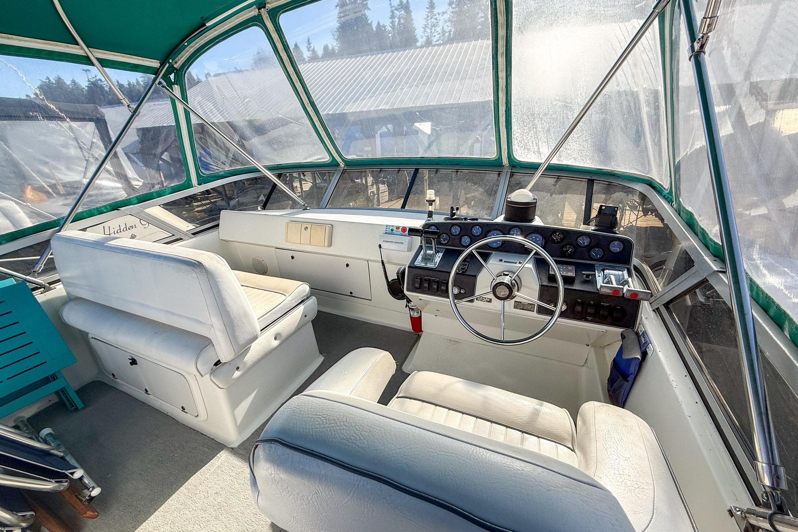 Interior view of 1994 Carver 320 Voyager boat cockpit with steering wheel and seating.