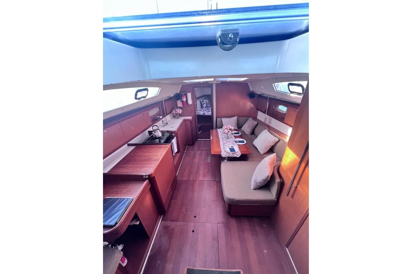 Interior of 2009 Beneteau Oceanis 40 sailboat, featuring cozy seating and wooden finishes.