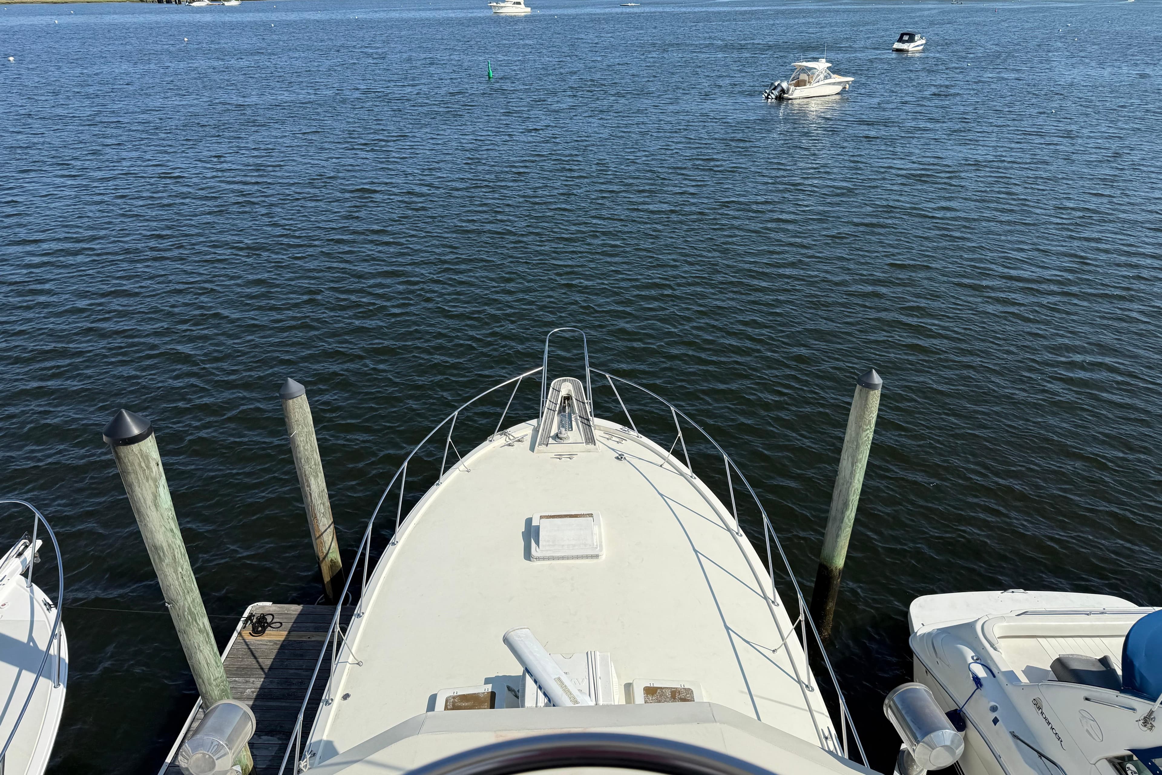 Bow view of 1979 Hatteras 46 Convertible yacht docked on calm water.