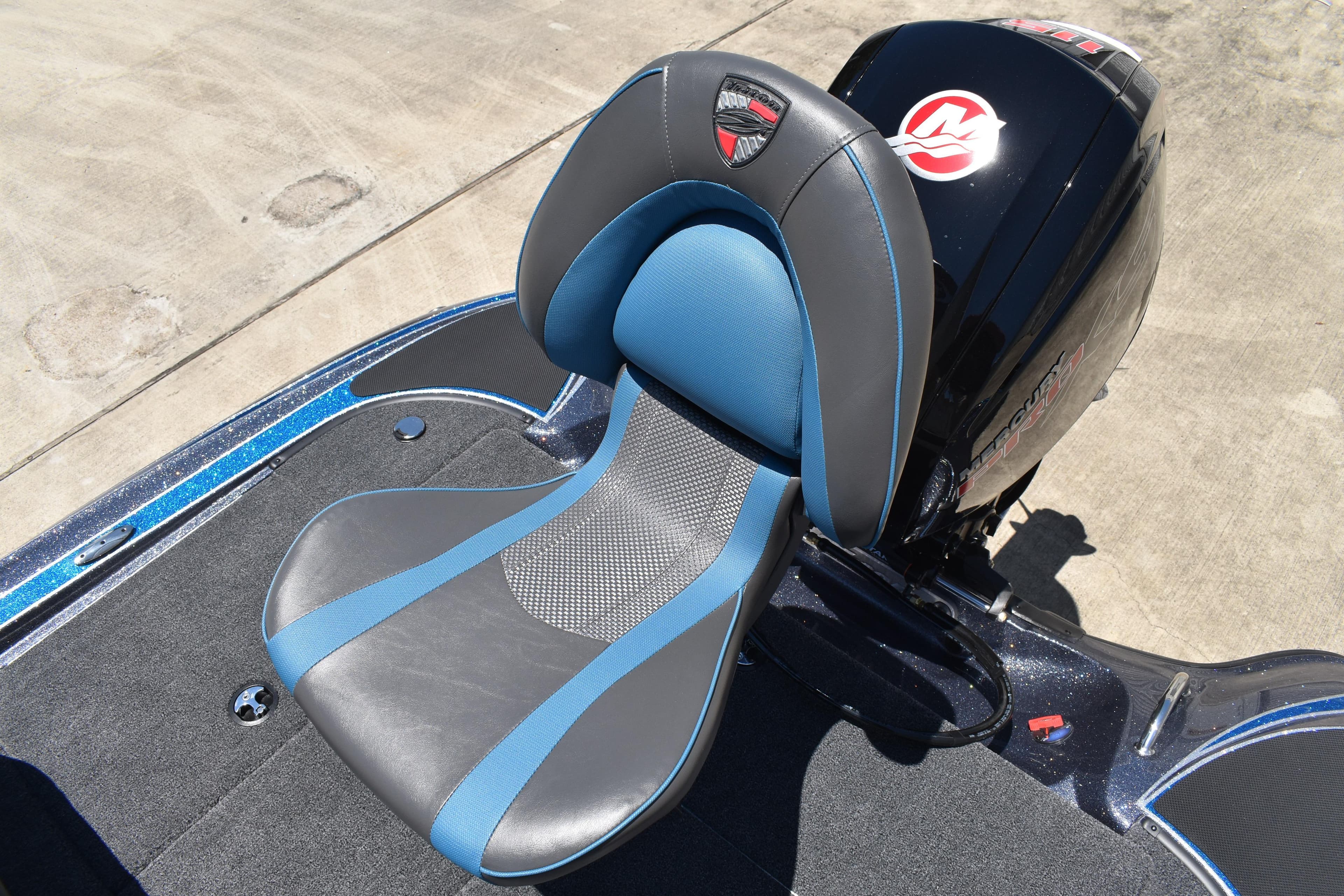 2026 Triton 179 TrX boat seat with blue and gray design, next to a powerful engine.