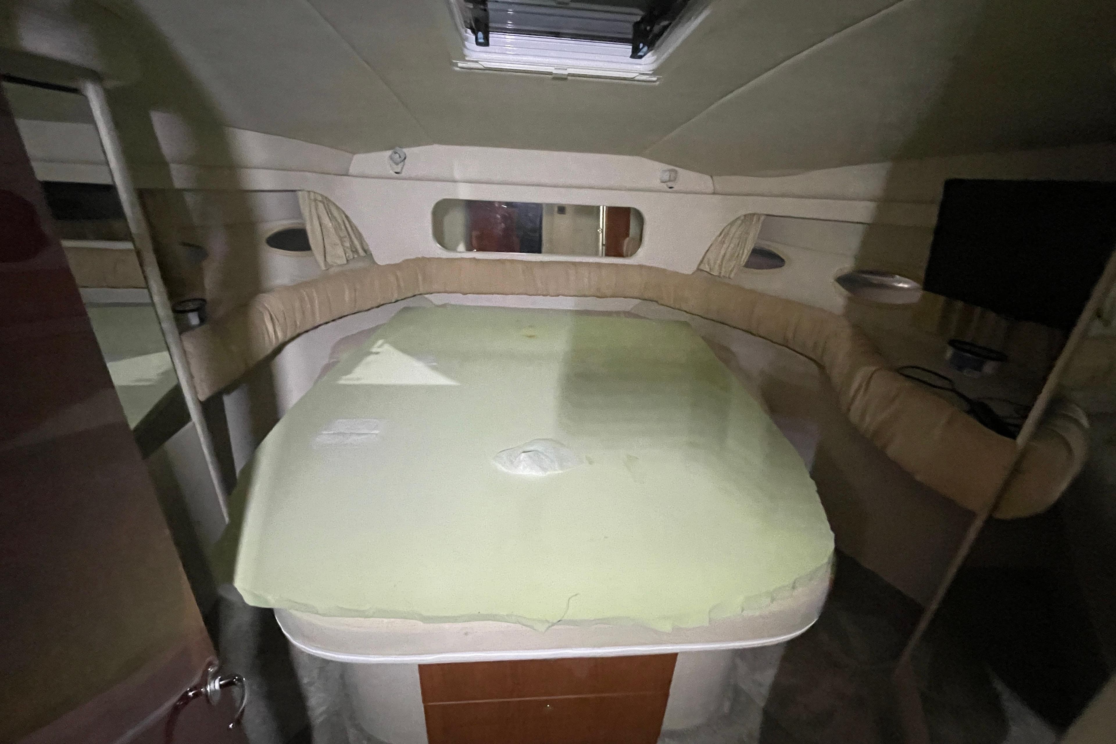 Interior cabin of 2000 Sea Ray 380 Aft Cabin yacht, featuring a bed and seating area.