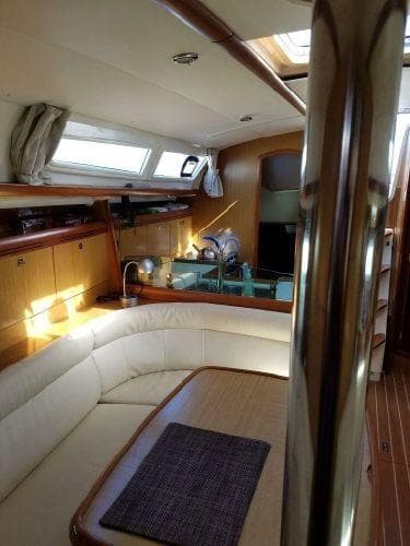 Interior of 2008 Jeanneau Sun Odyssey 39i yacht with cozy seating and wooden finishes.