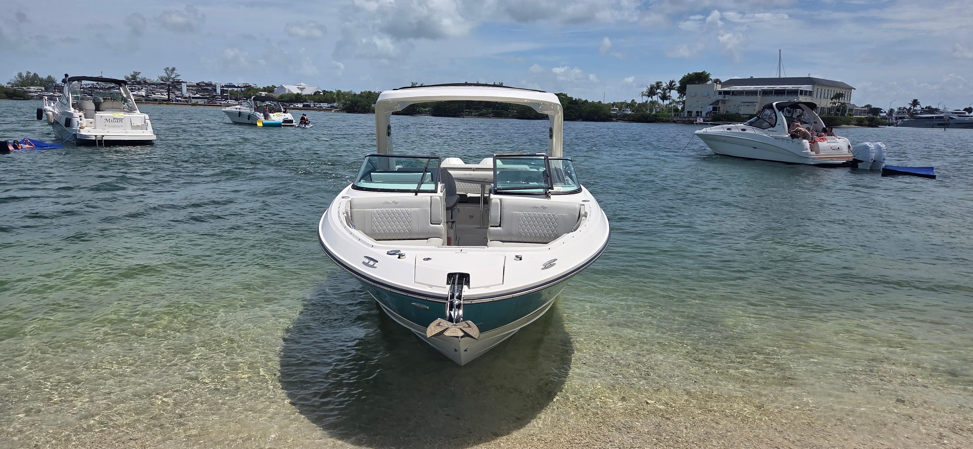 2021 Sea Ray SLX 310 Outboard boat anchored on a sunny beach.