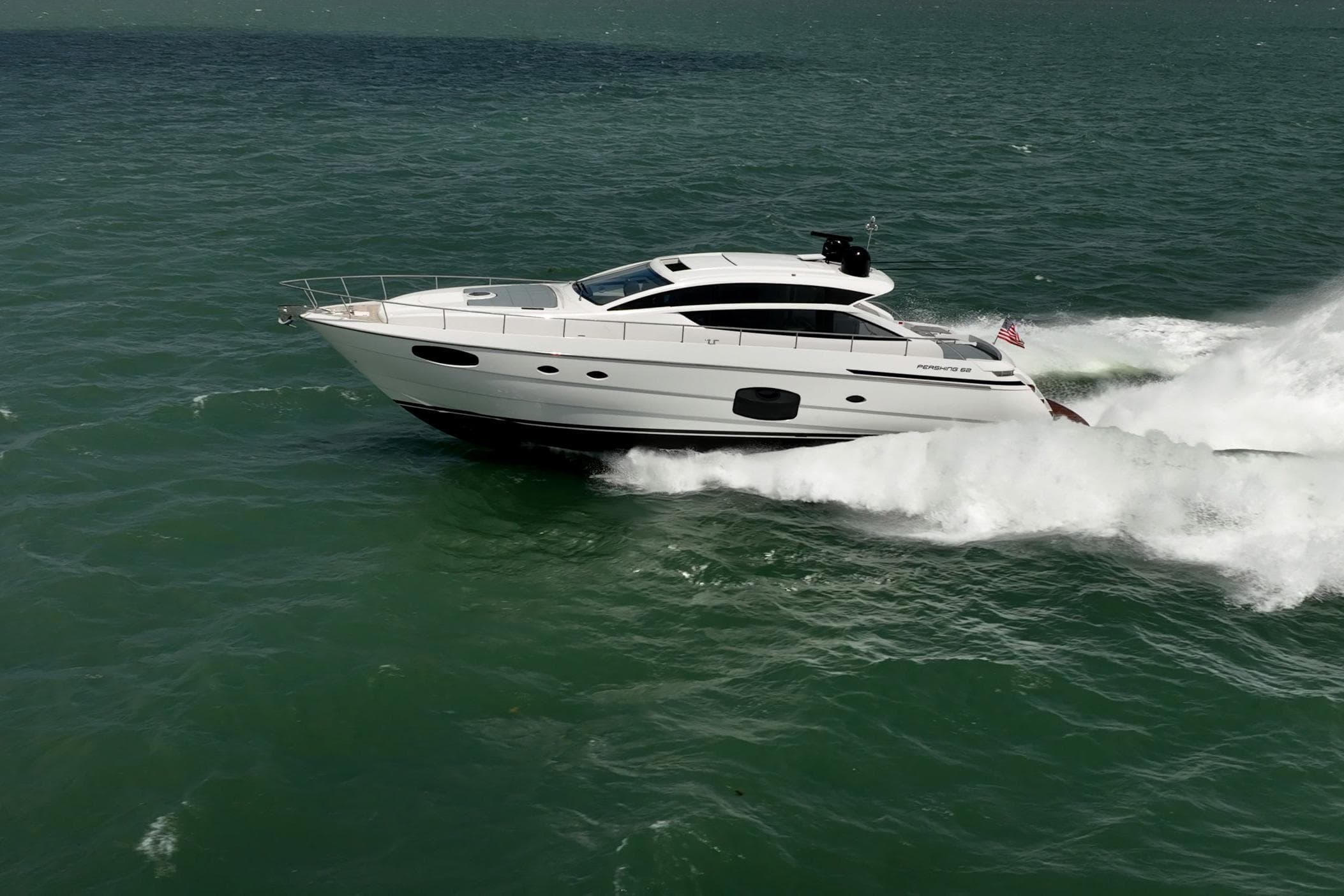 2020 Pershing 62 yacht cruising at high speed on open sea.