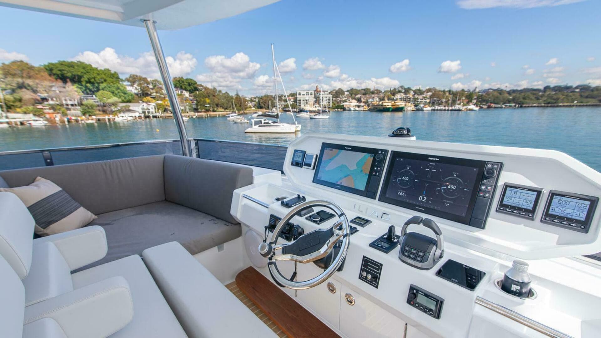 Luxurious ILIAD 53F yacht cockpit with modern navigation system, overlooking serene waterfront.