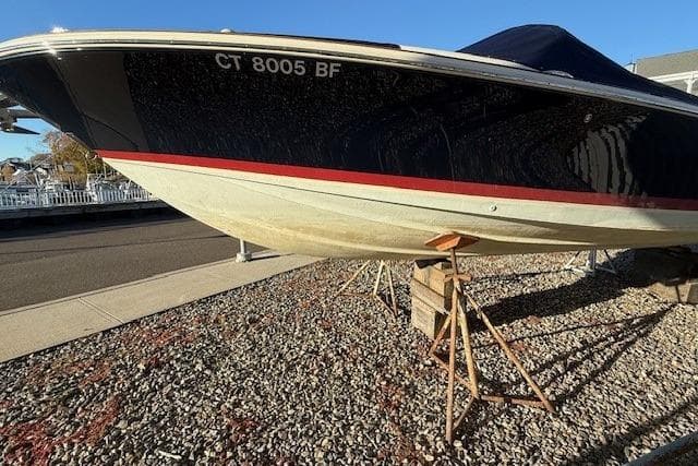 2014 Chris-Craft Launch 25 boat on stands, parked on gravel.