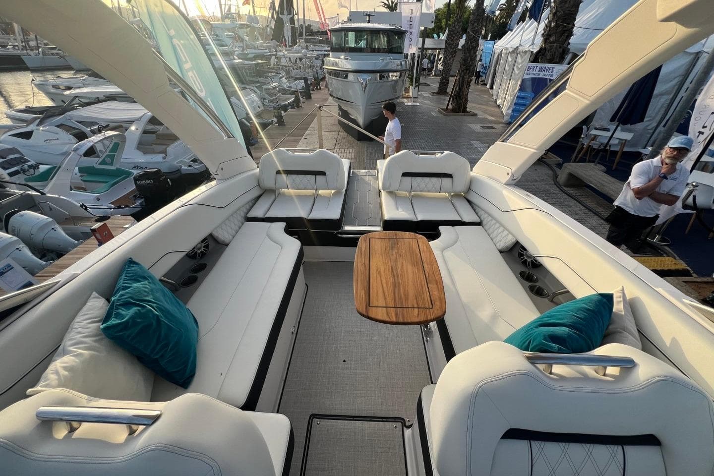 Luxurious 2025 Regal LS6 boat interior with plush seating and wooden table at a marina.