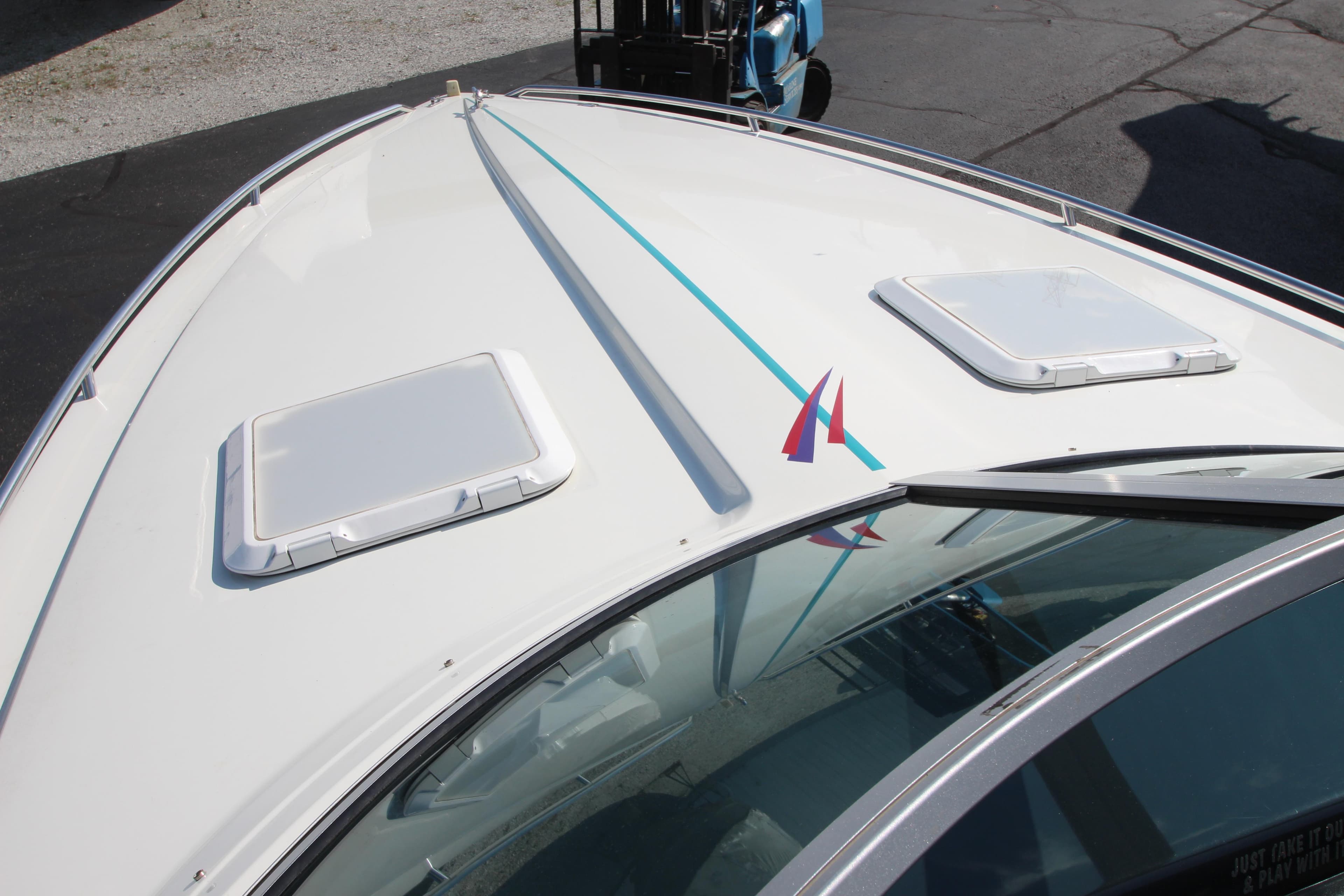 1995 Formula SR1 303 boat deck with hatches and blue stripe.