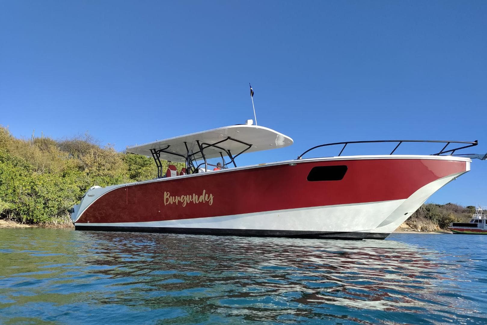2024 YachtCat 41 in water, red and white design, clear blue sky background.