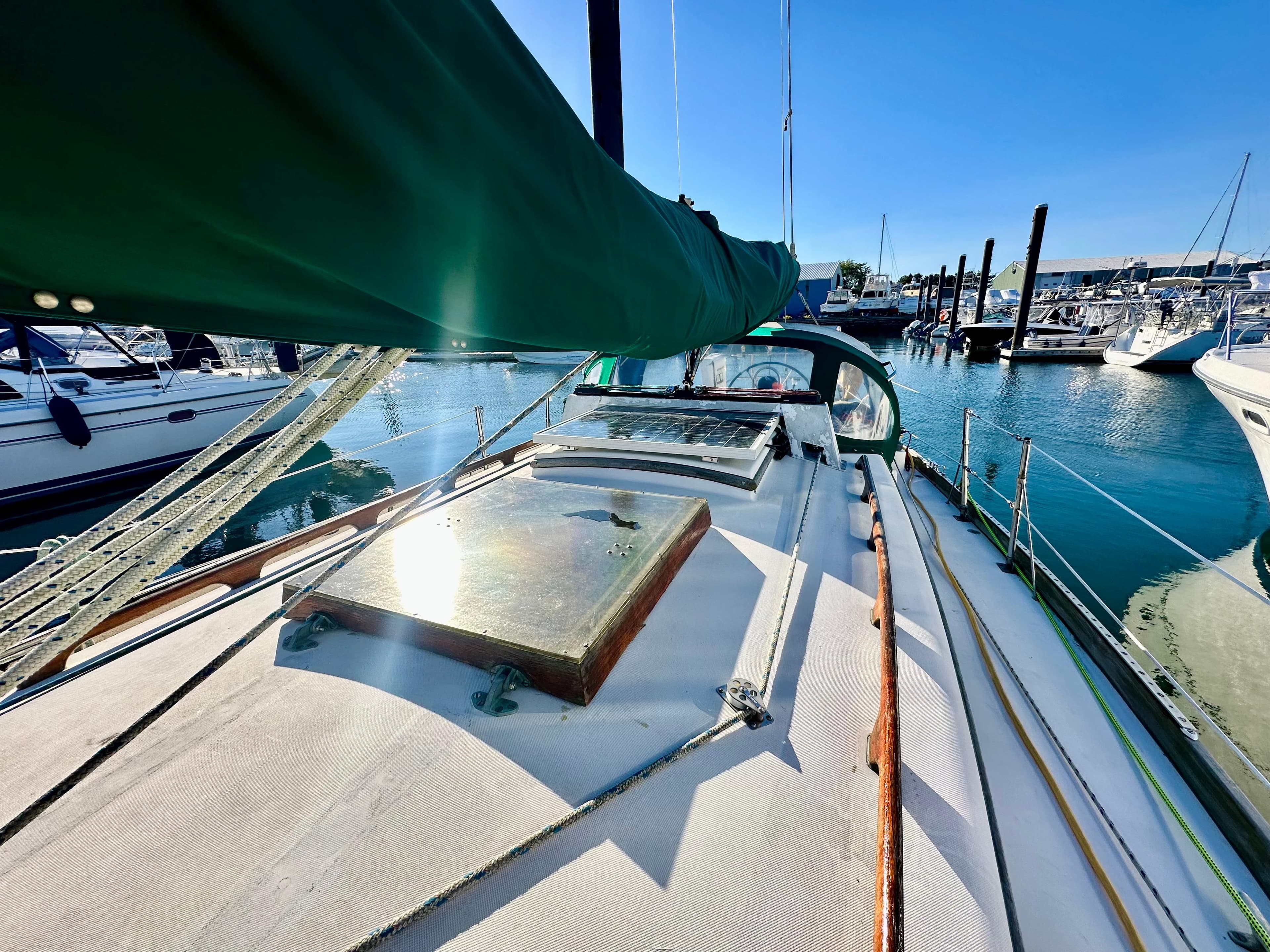 1981 Bristol 40 sailboat docked in a sunny marina, showcasing deck and green sail.