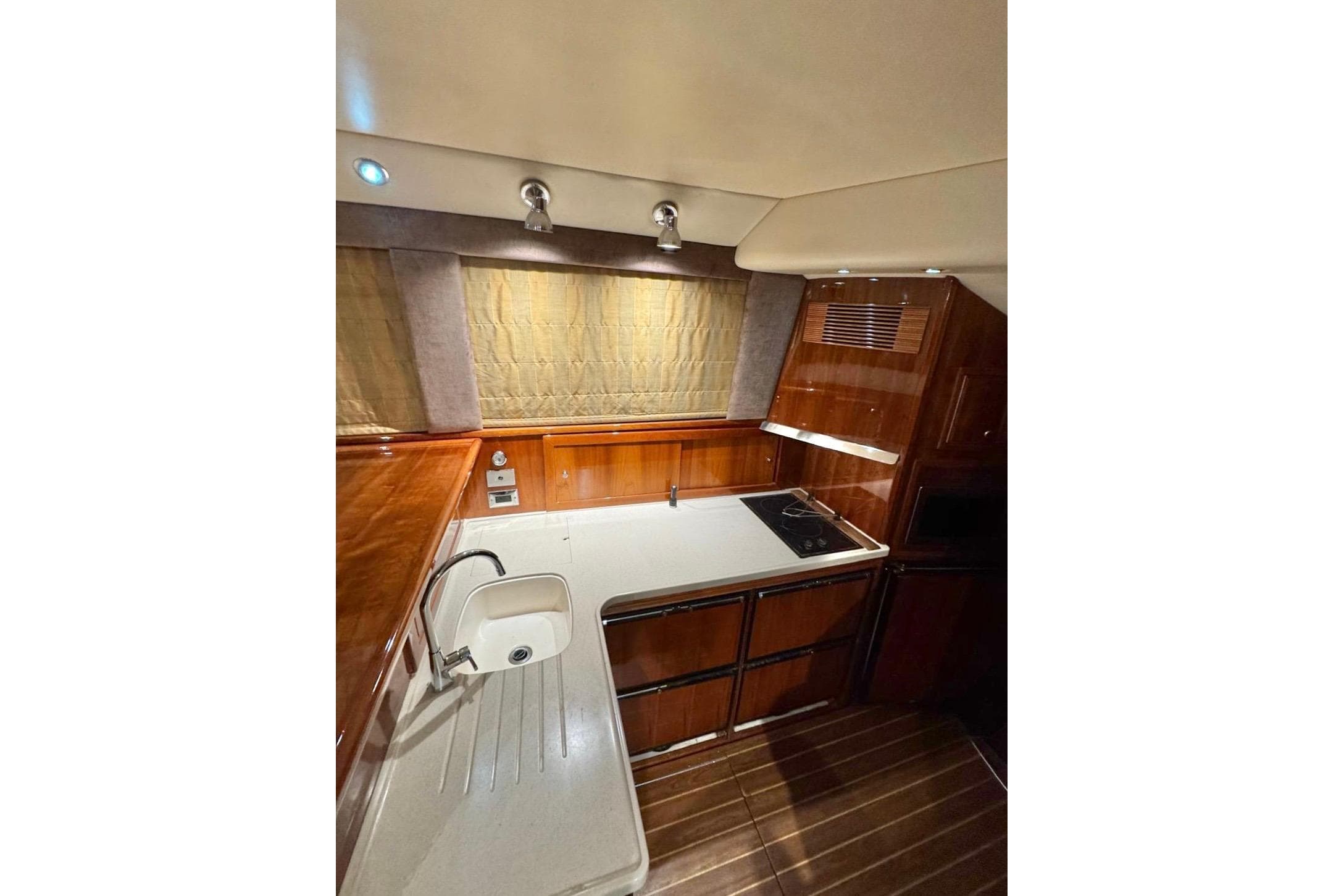 Luxurious 2004 Riviera 51 Flybridge yacht kitchen with wood cabinetry and modern appliances.