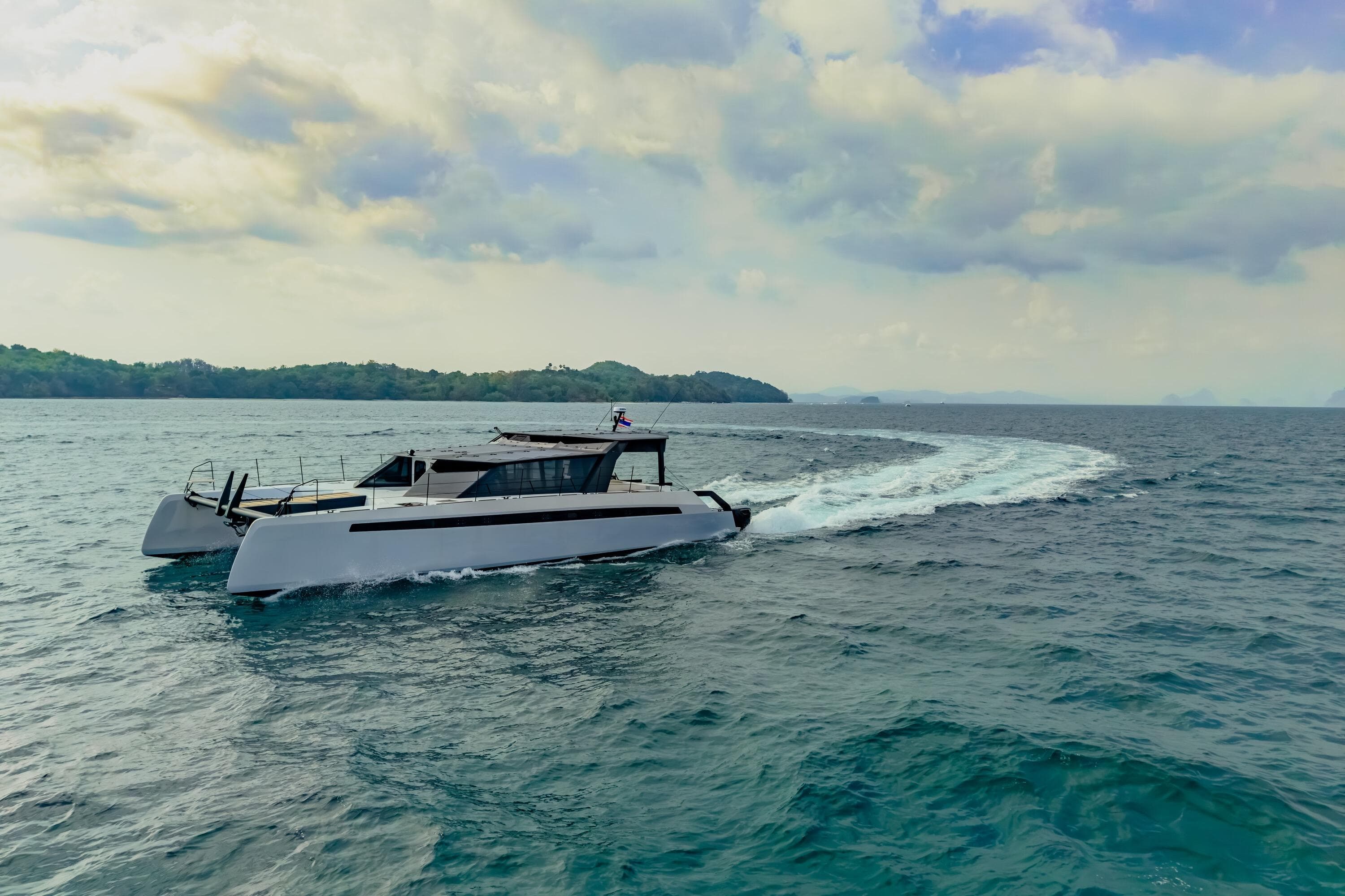 2025 Adventure Yachts AY60 Sport cruising on open sea under cloudy sky.