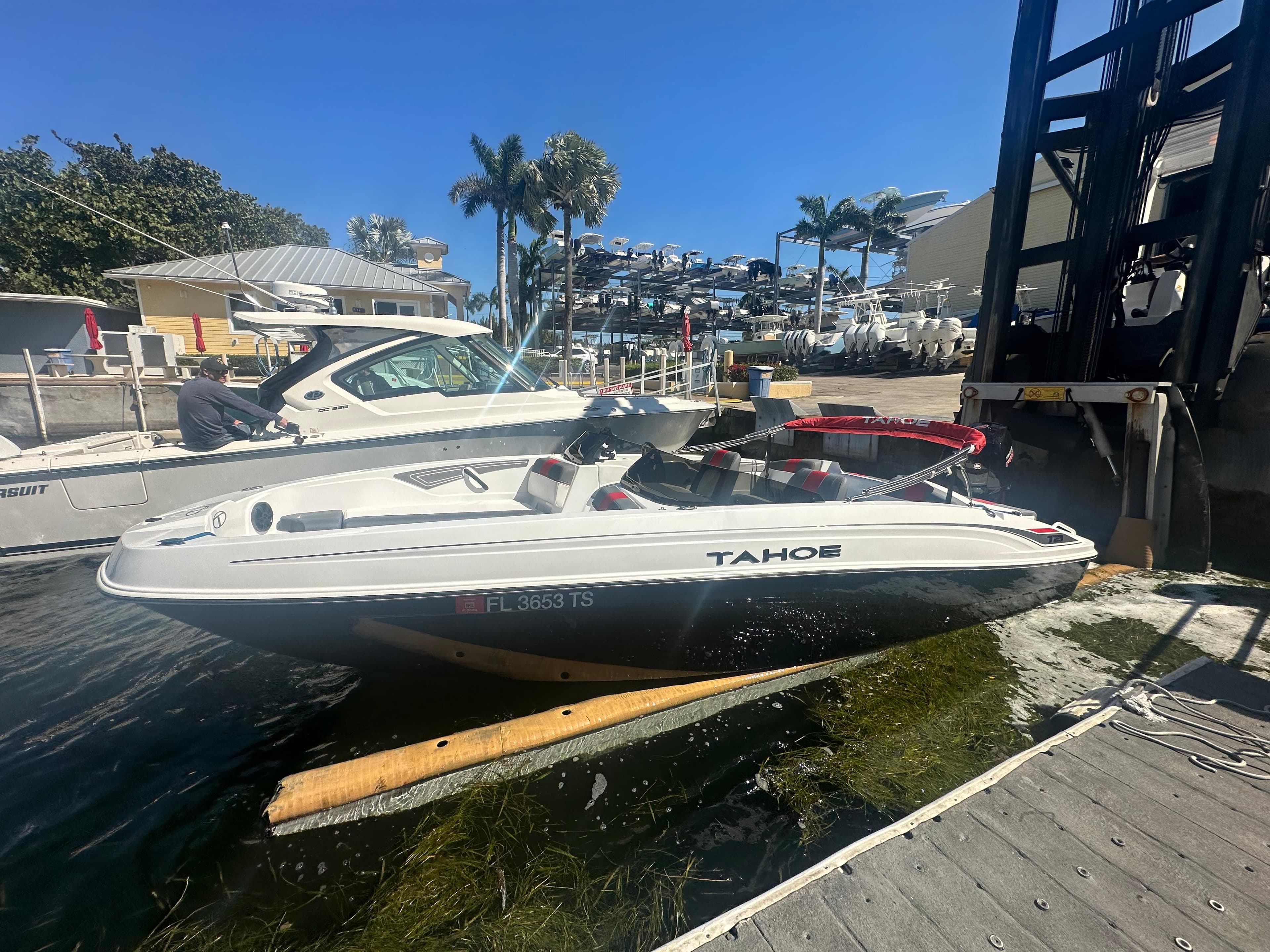 2024 Tahoe T21 boat docked at a marina with palm trees in the background.