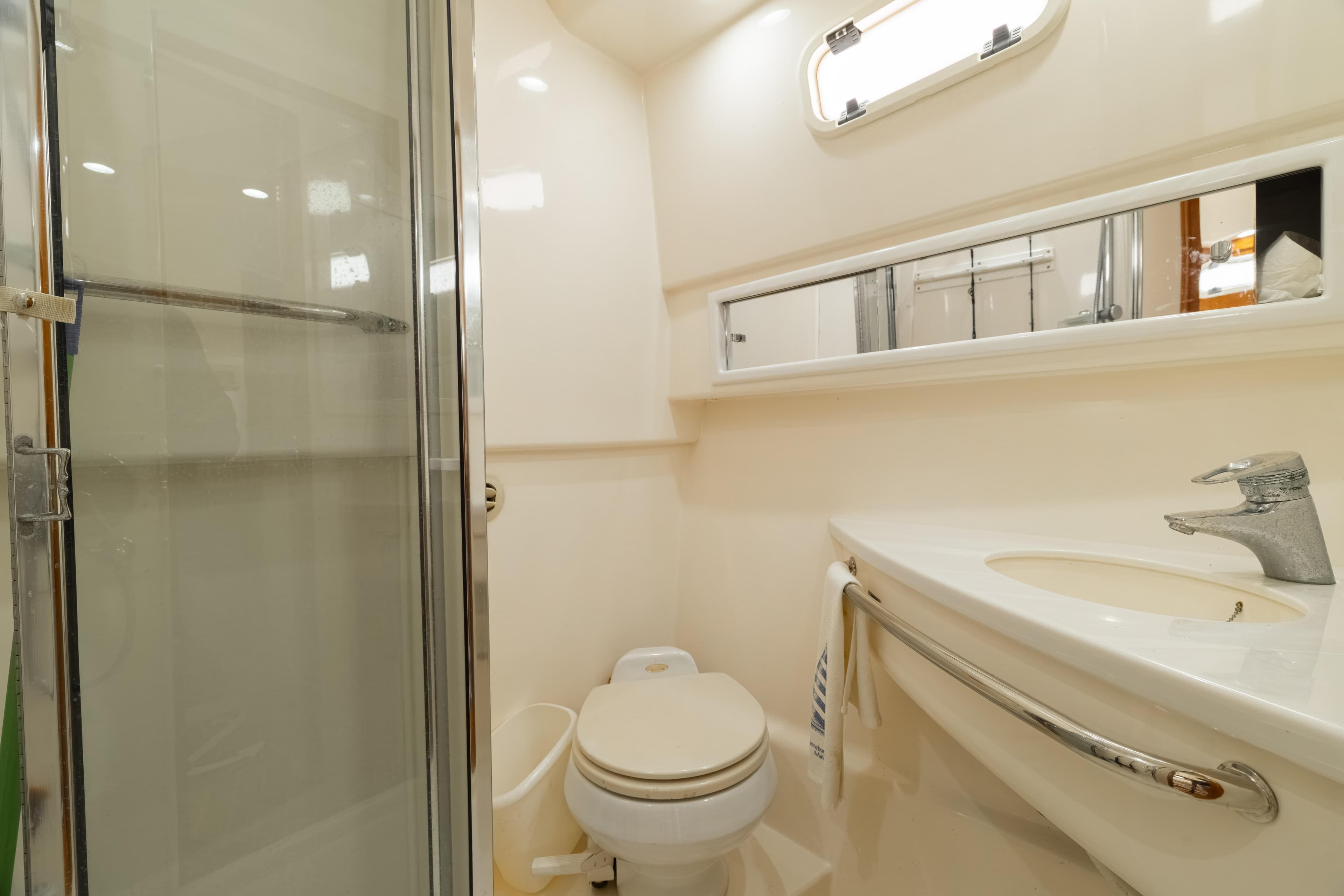 Luxurious bathroom in 2006 Cabo 35 Express yacht with shower, sink, and toilet.