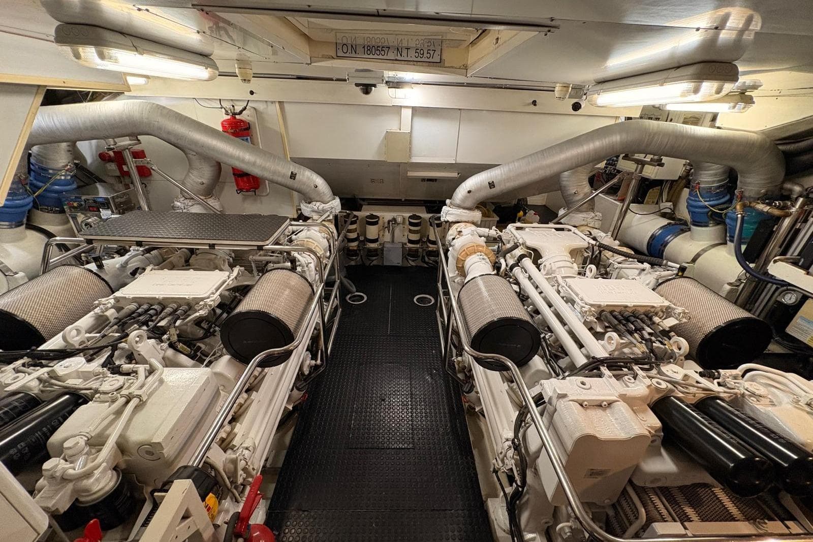Engine room of 2006 Mochi Craft 74' Dolphin yacht, showcasing dual engines and mechanical systems.