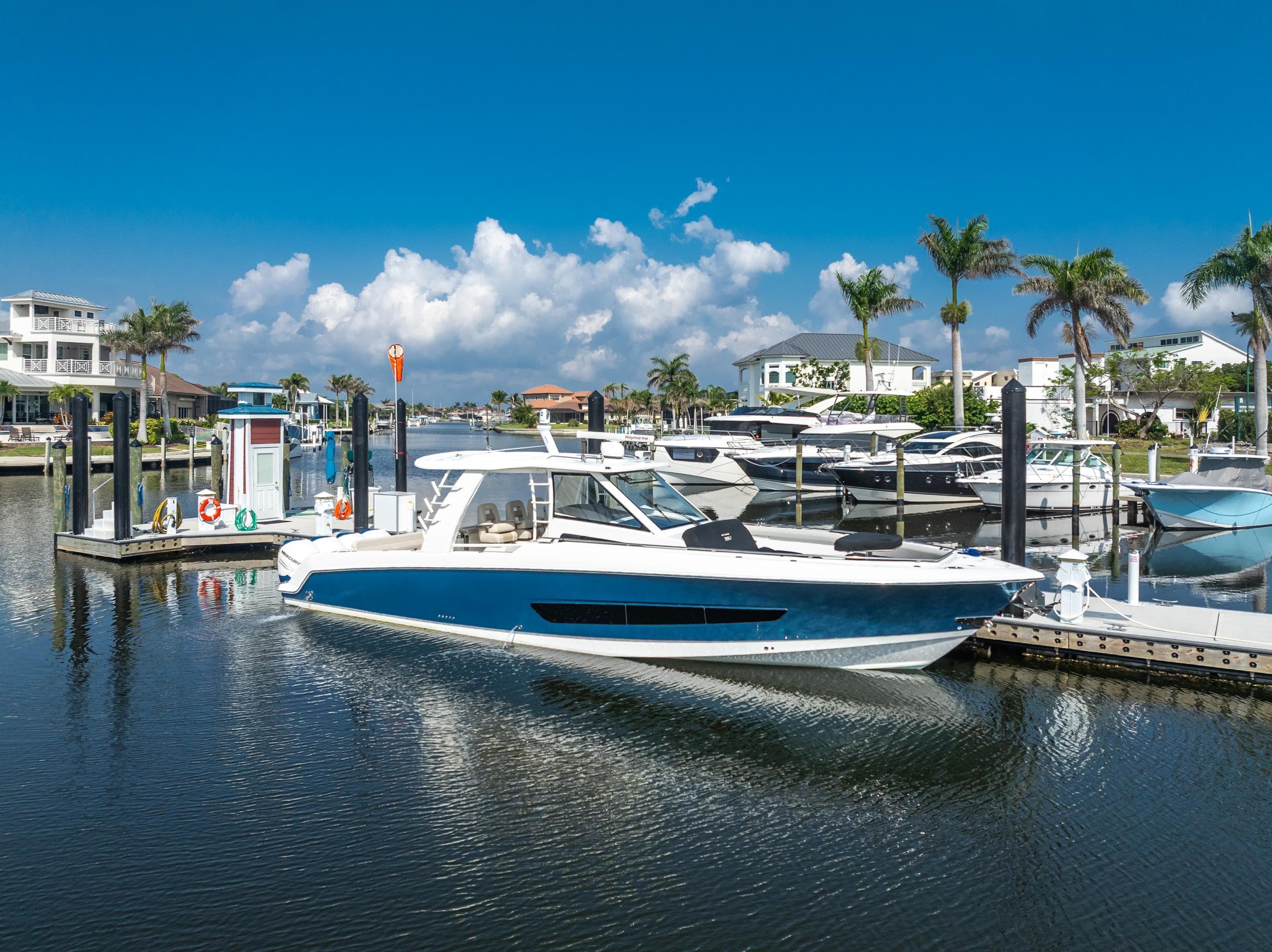 2019 Boston Whaler 420 Outrage docked in a sunny marina with palm trees.