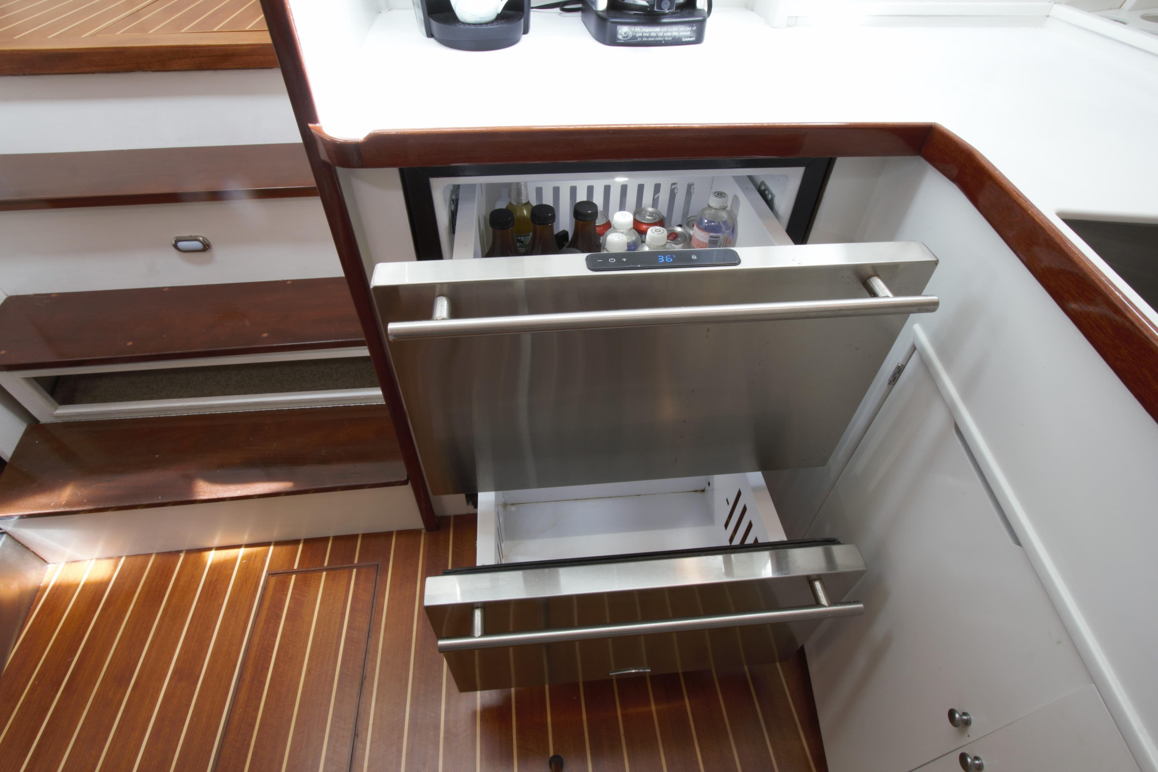 1963 Huckins Linwood yacht interior with modern stainless steel drawer fridge.