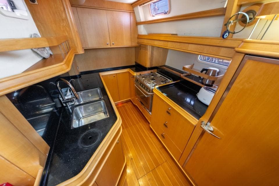 Luxurious yacht kitchen with wooden cabinetry, dual sinks, and modern appliances, Discovery 67, 2011 model.