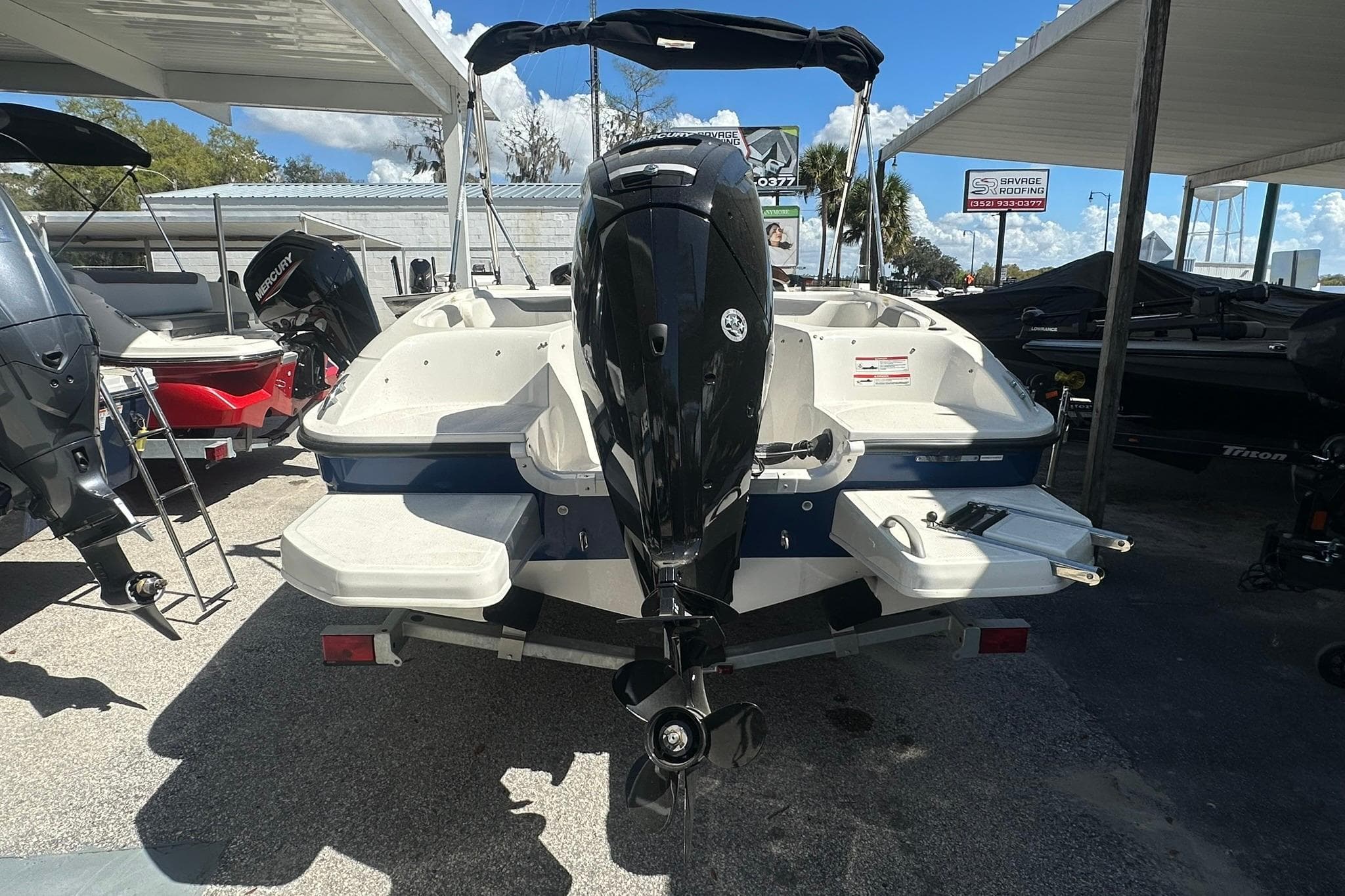 2025 Bayliner Element E18 boat with outboard motor, parked under a canopy.