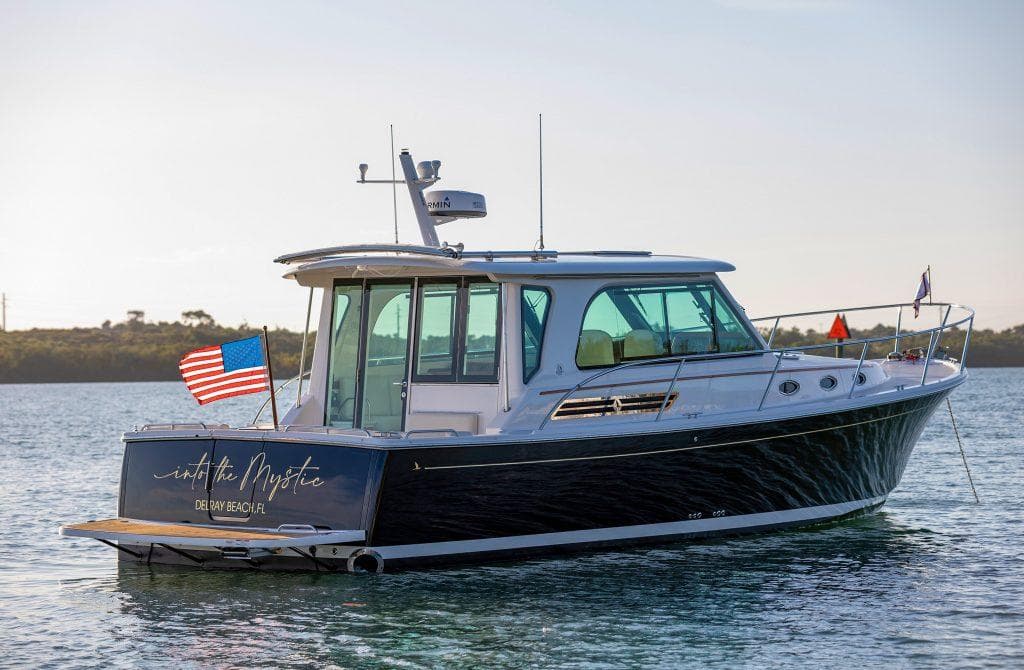 Back Cove 372 boat, 2026 model, on calm water with American flag.