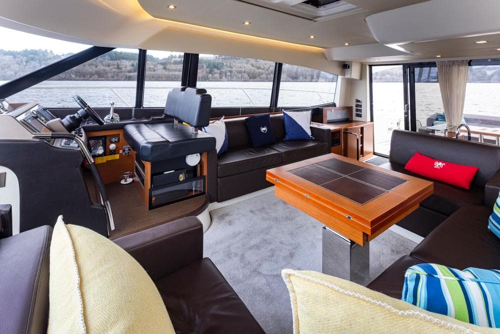 Luxurious interior of a 2017 Prestige 560 yacht with modern seating and scenic windows.