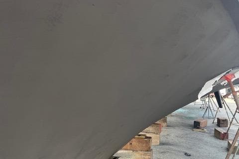 1988 Hatteras 70 yacht hull on dry dock with support blocks.