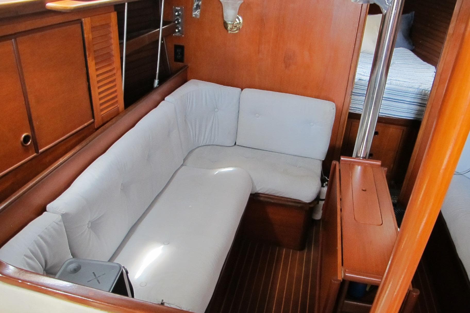 Interior of 1985 Beneteau Idylle 11.50 yacht with cozy seating and wooden finish.