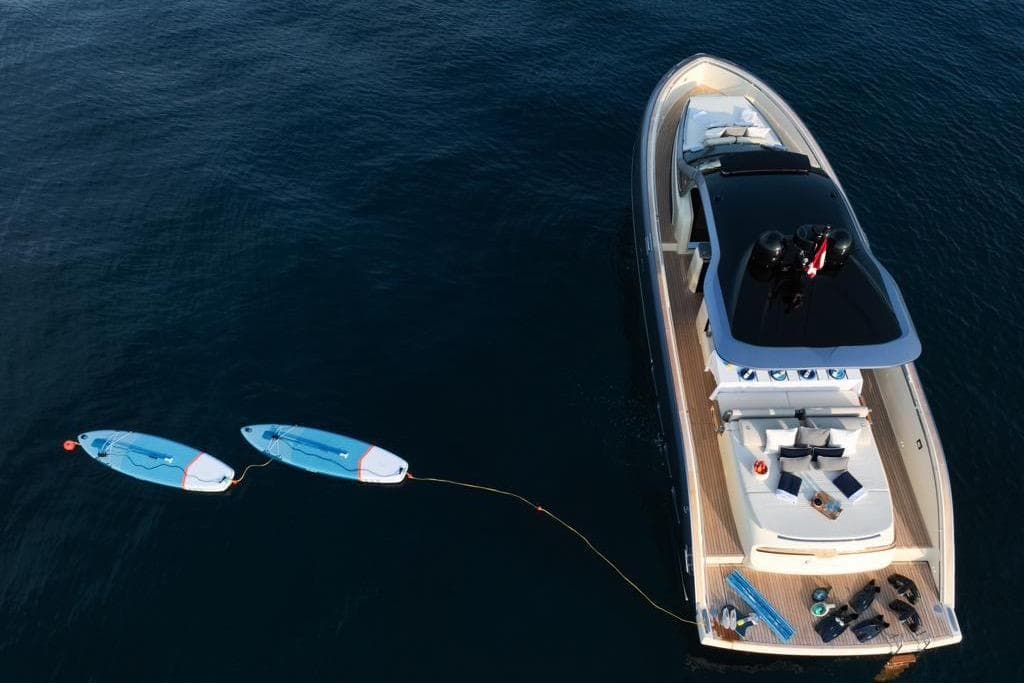 2023 Invictus 460TT yacht with paddleboards on calm water.