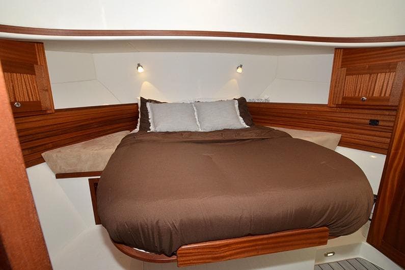 Cozy bedroom in 2020 American Tug 362 with wood accents and ambient lighting.