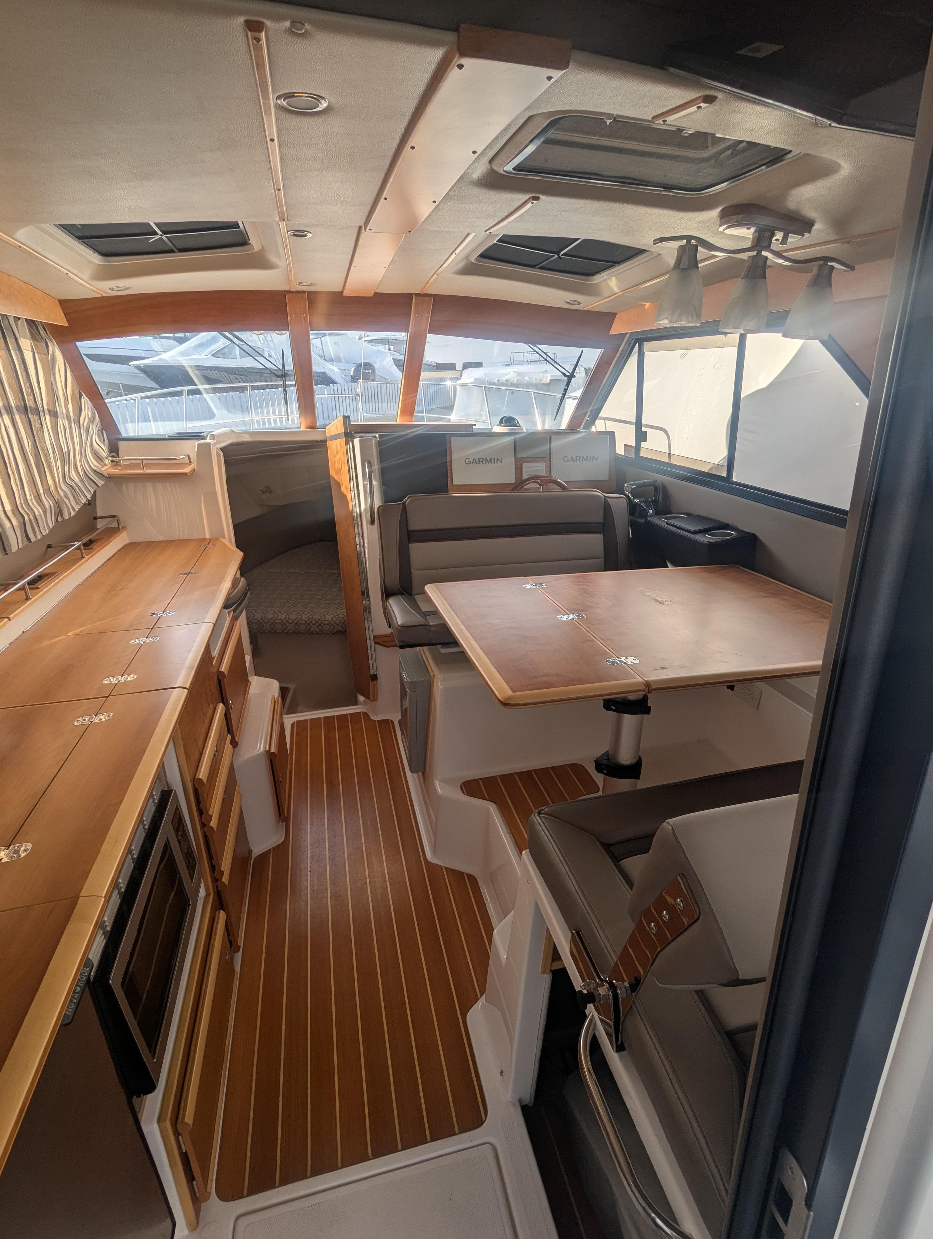 Interior of 2022 Cutwater C-32 CB boat with wood accents and seating area.