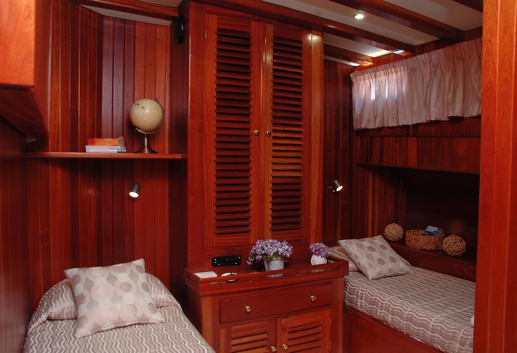 Luxurious wooden cabin interior on a 2000 Gulet 38m yacht with twin beds and decor.