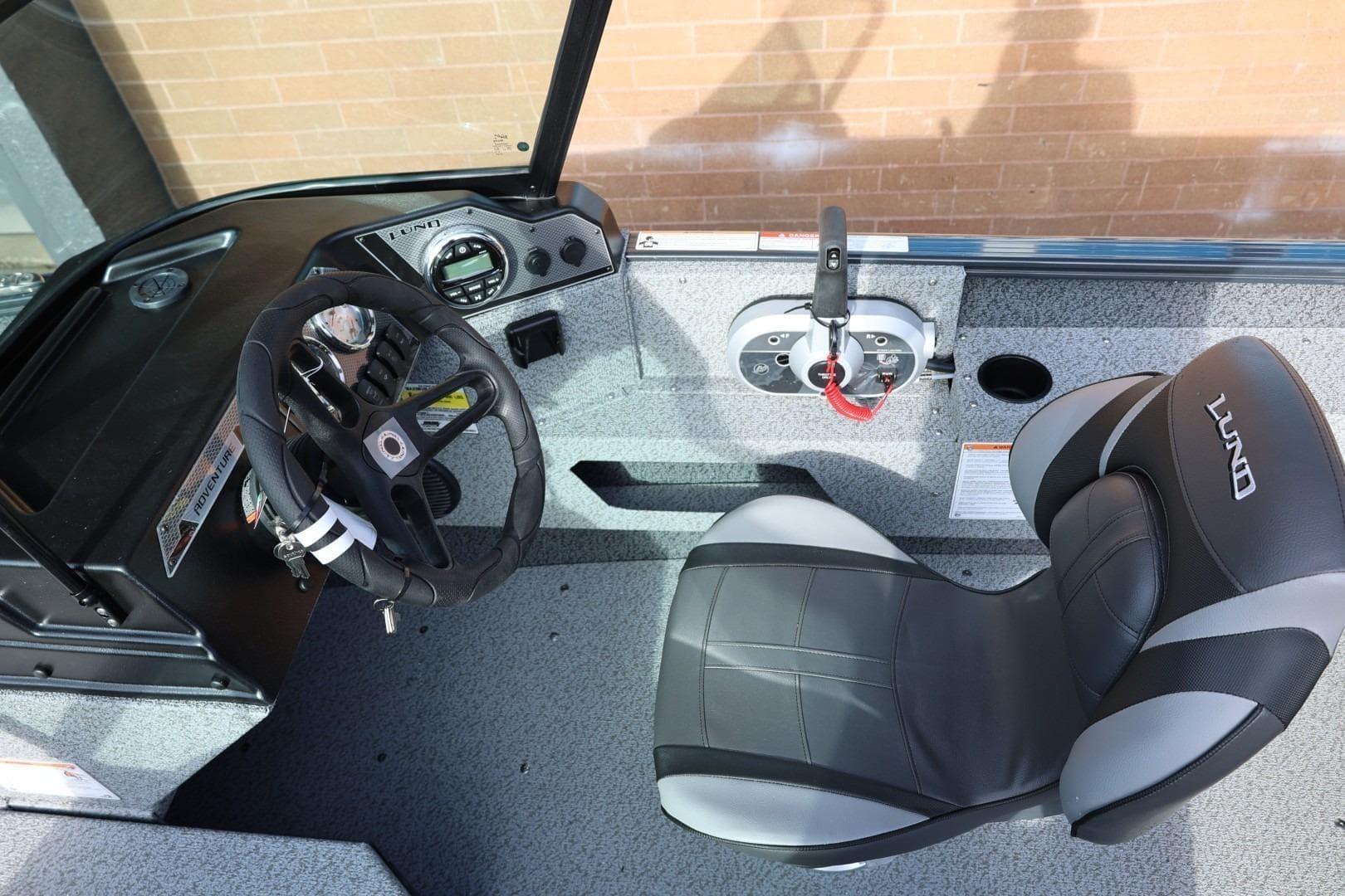 2026 Lund 1675 Adventure Sport boat interior with steering wheel and seat.