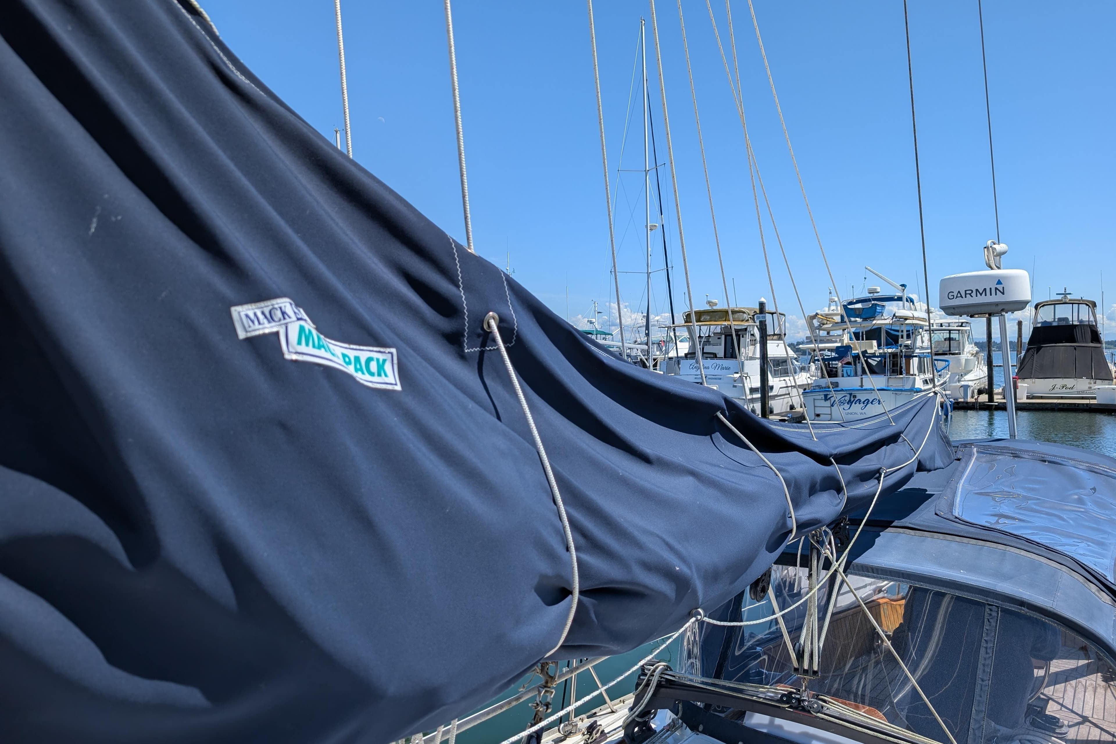 Sailboat with Mack Pack cover in marina, Ohlson 38, 1984 model, clear blue sky.