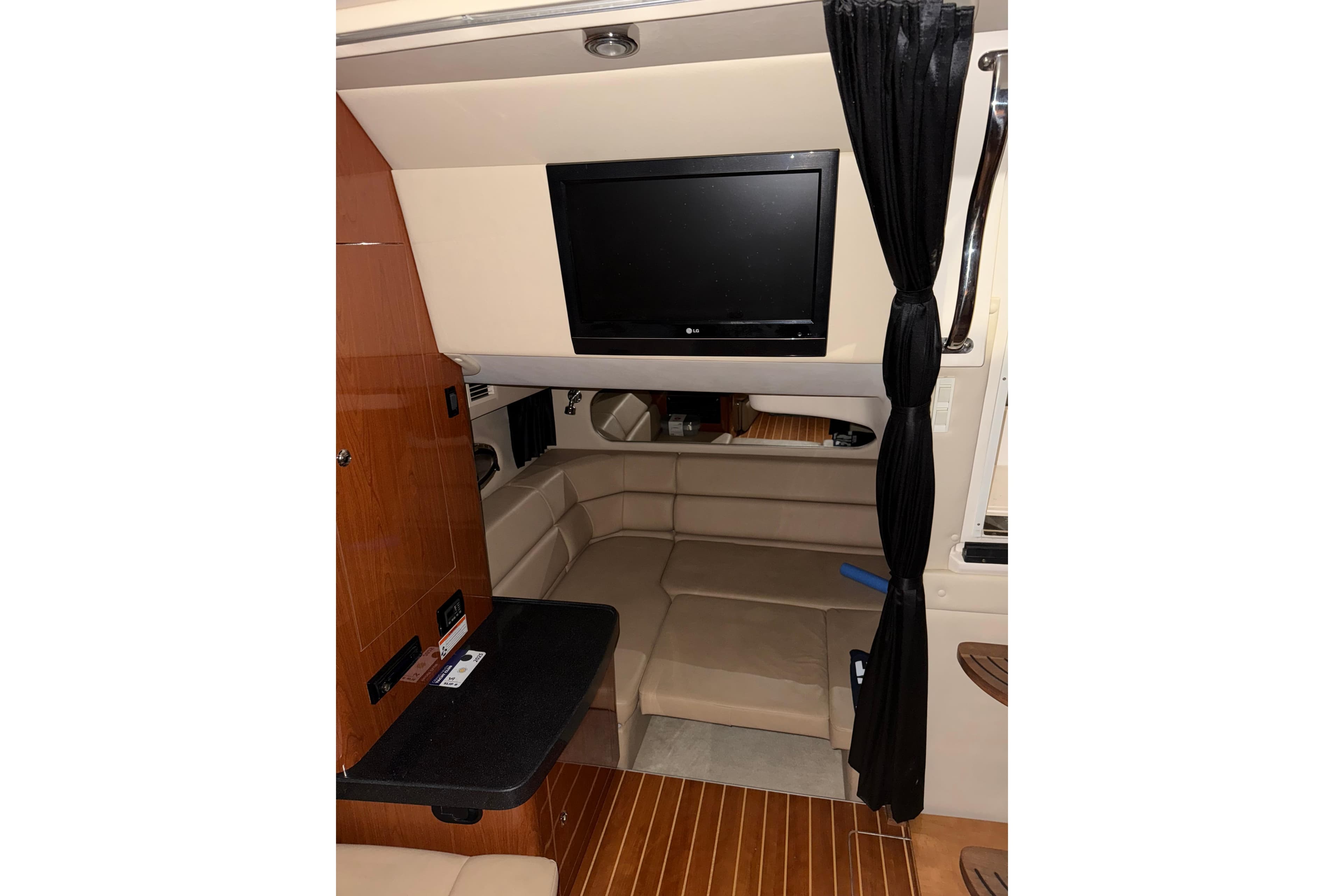 2009 Regal Commodore 3760 IO interior with TV, seating, and wood accents.