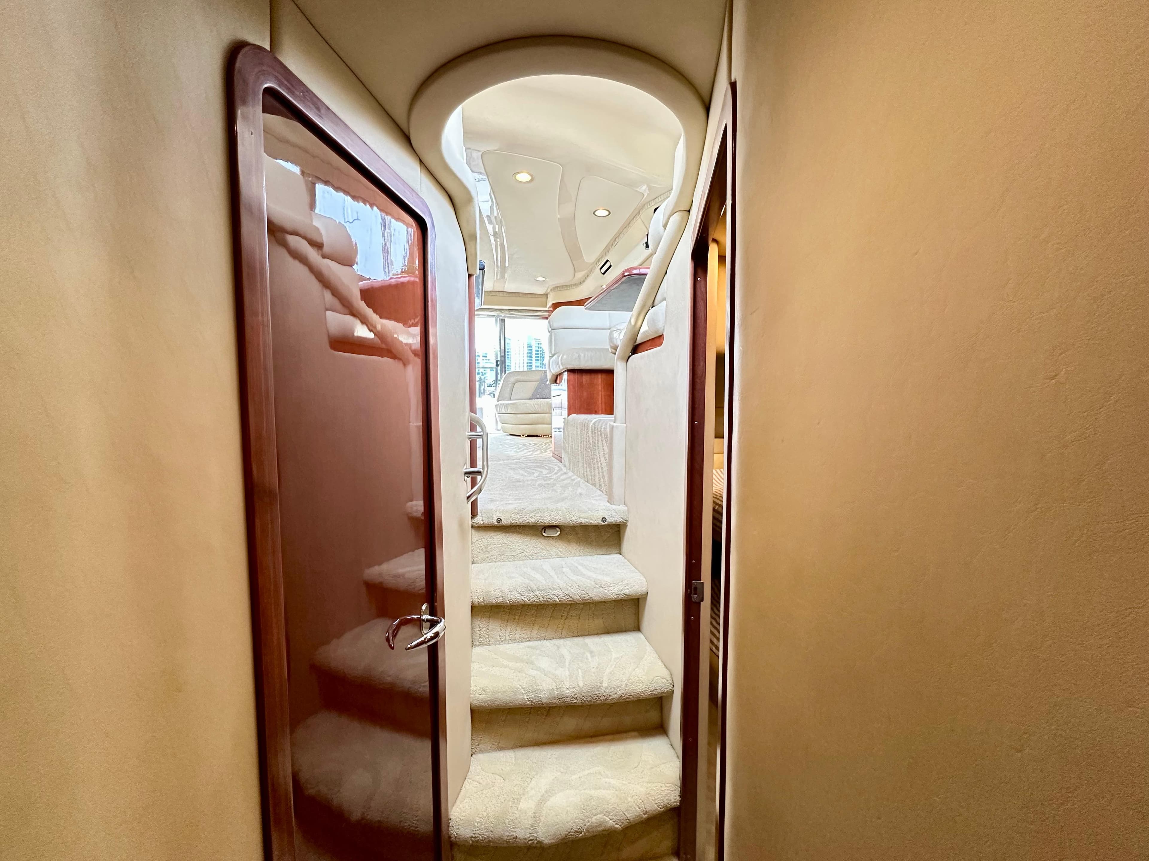 Interior staircase of 2002 Sea Ray 560 Sedan Bridge yacht, featuring elegant design and plush carpeting.