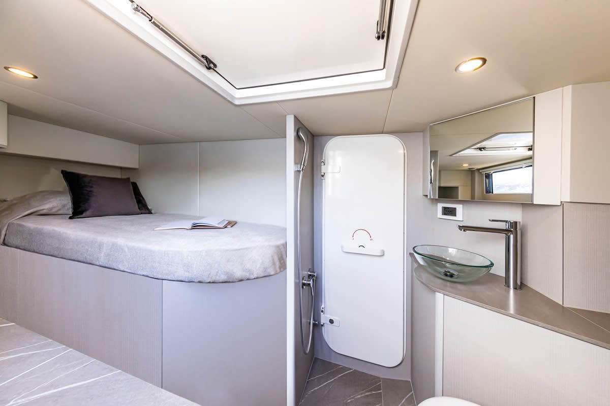 Luxurious interior of 2025 Absolute 53 Navetta yacht with modern bedroom and bathroom.