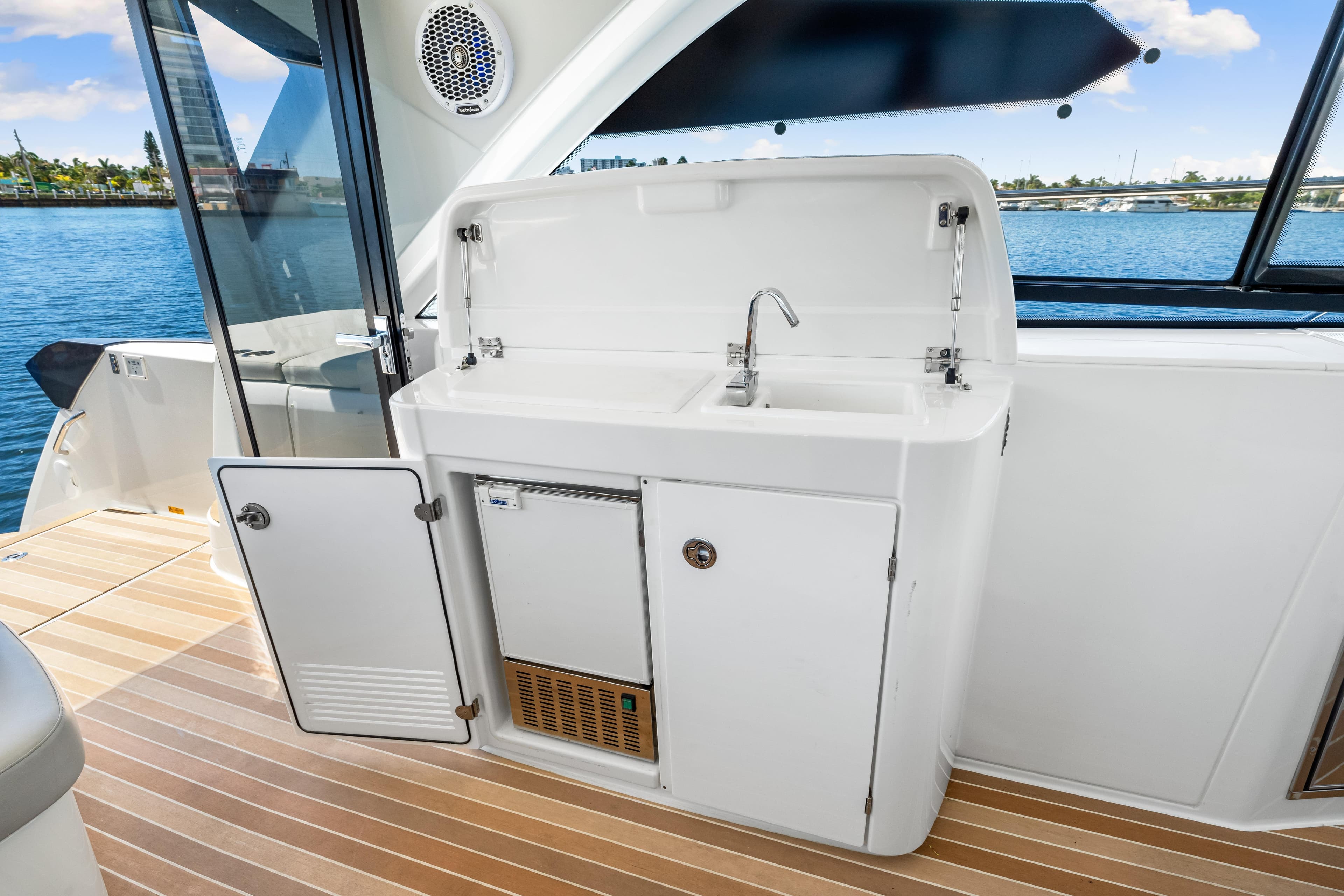 2024 Beneteau Gran Turismo 45 yacht kitchenette with sink and storage, overlooking water.