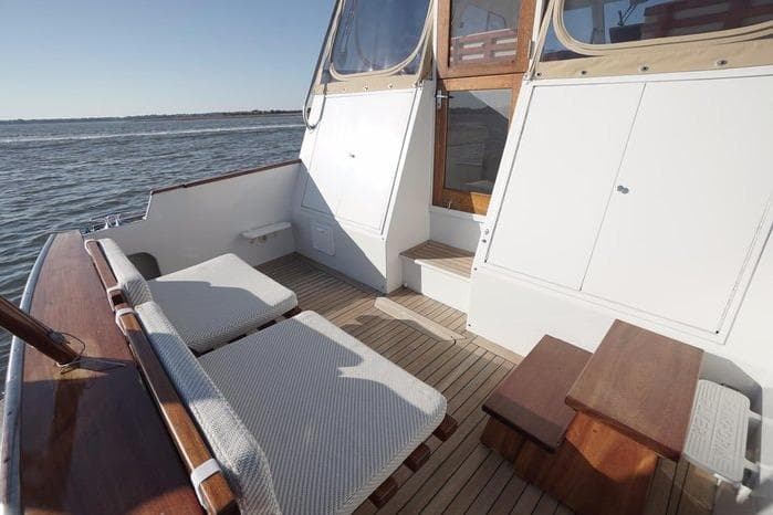 2003 Huckins Atlantic 44 yacht deck with seating, wooden flooring, and ocean view.