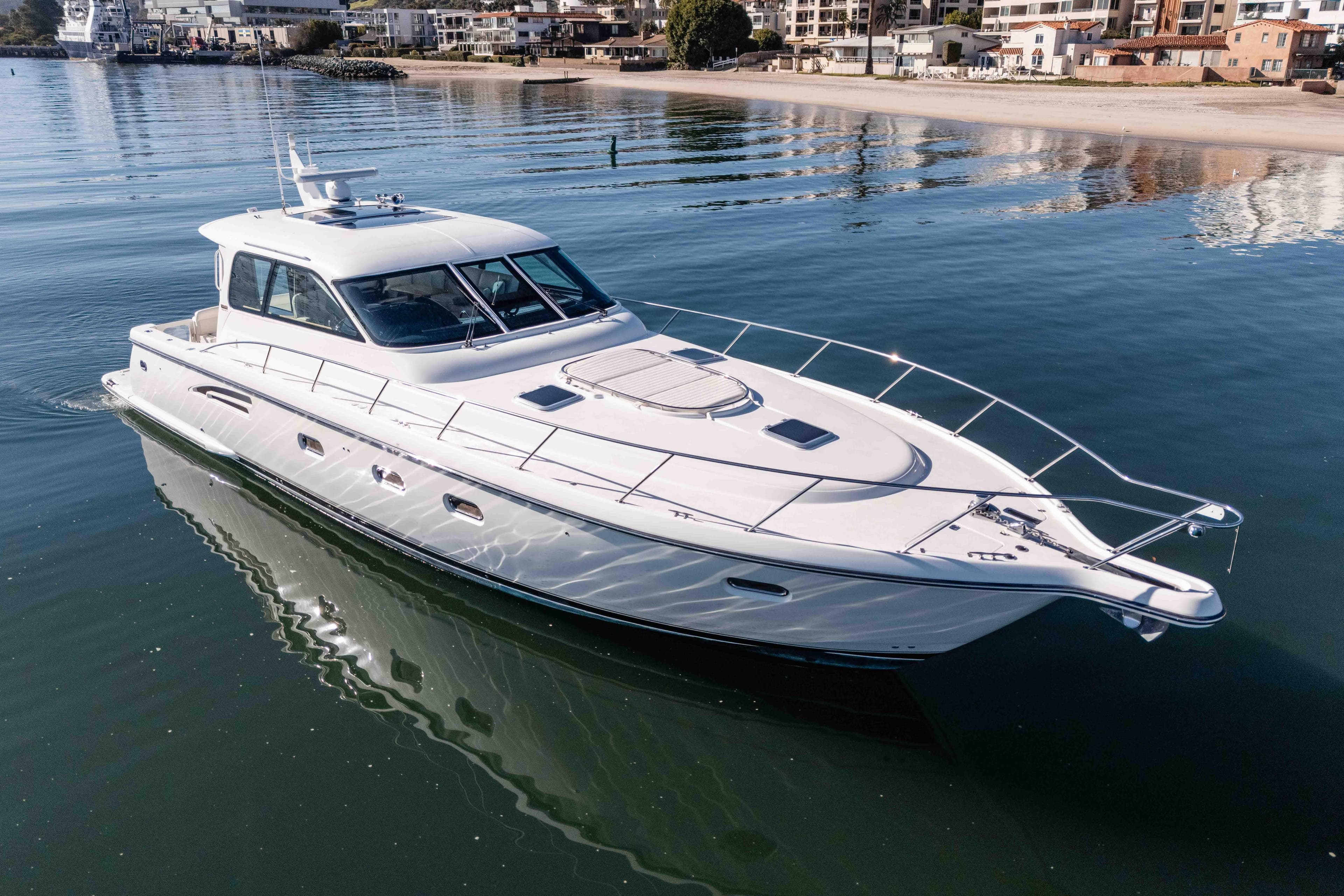 2006 Tiara Yachts 5200 Sovran Salon cruising on calm waters near a coastal town.