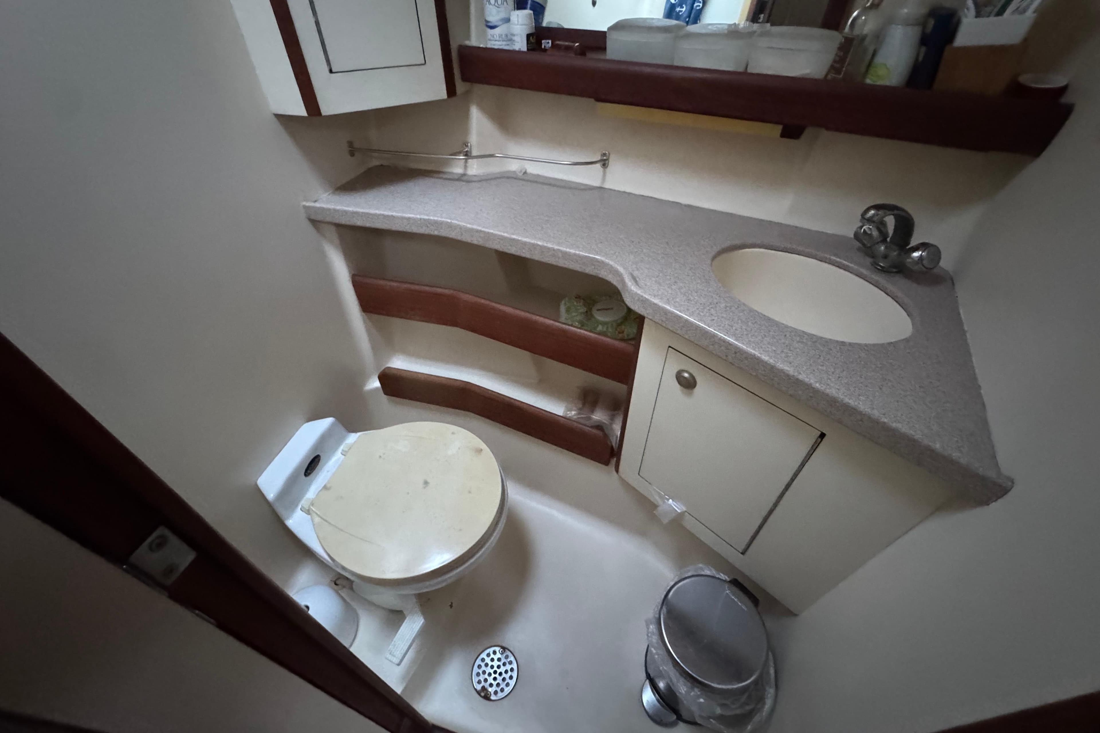 Compact bathroom in a 2000 Hunter 460 yacht with toilet, sink, and storage.