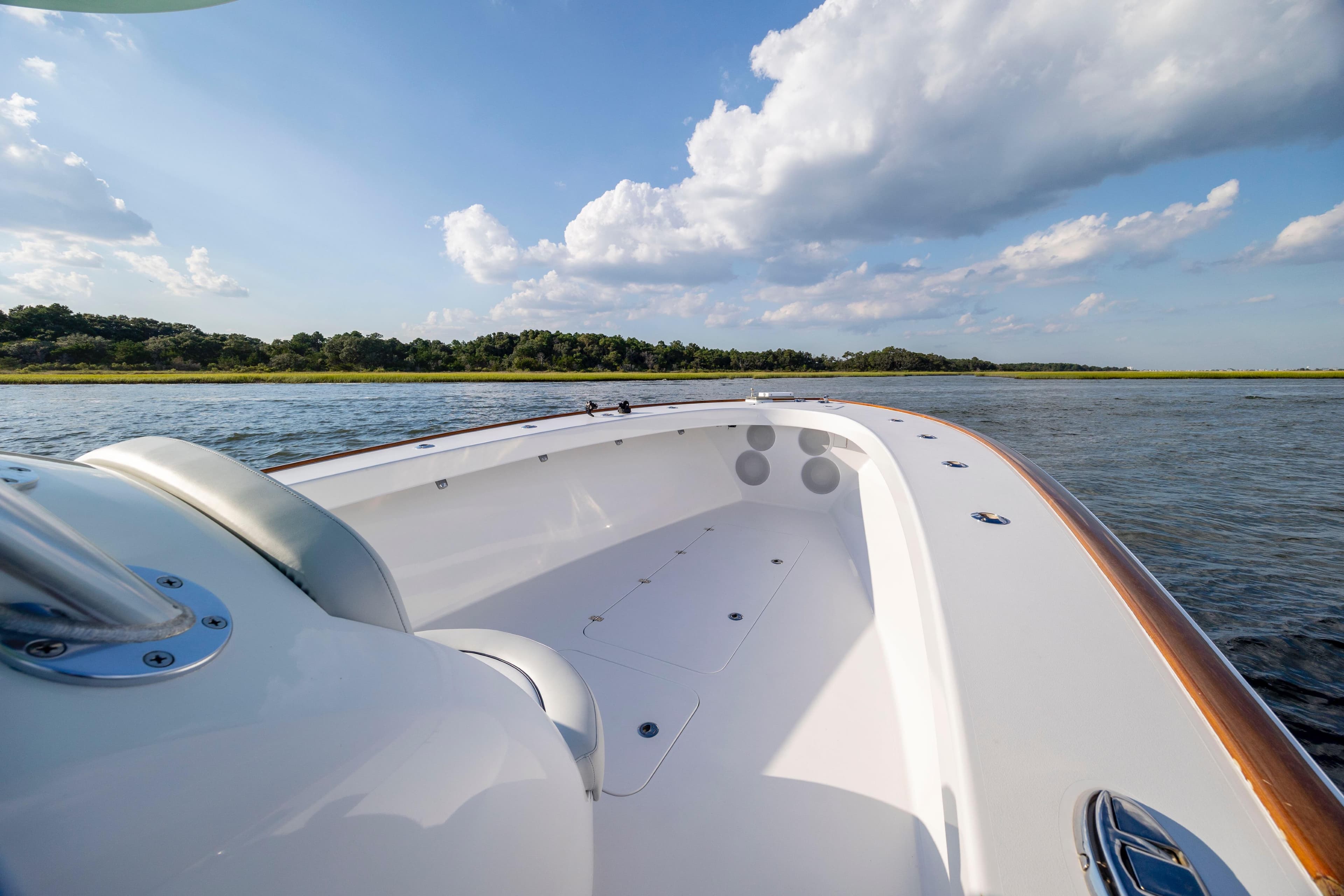 2018 Tribute 37 boat on calm water under a blue sky with clouds.