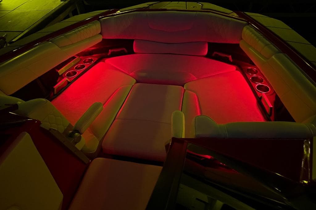 2021 Malibu M240 boat interior with red ambient lighting and cup holders.