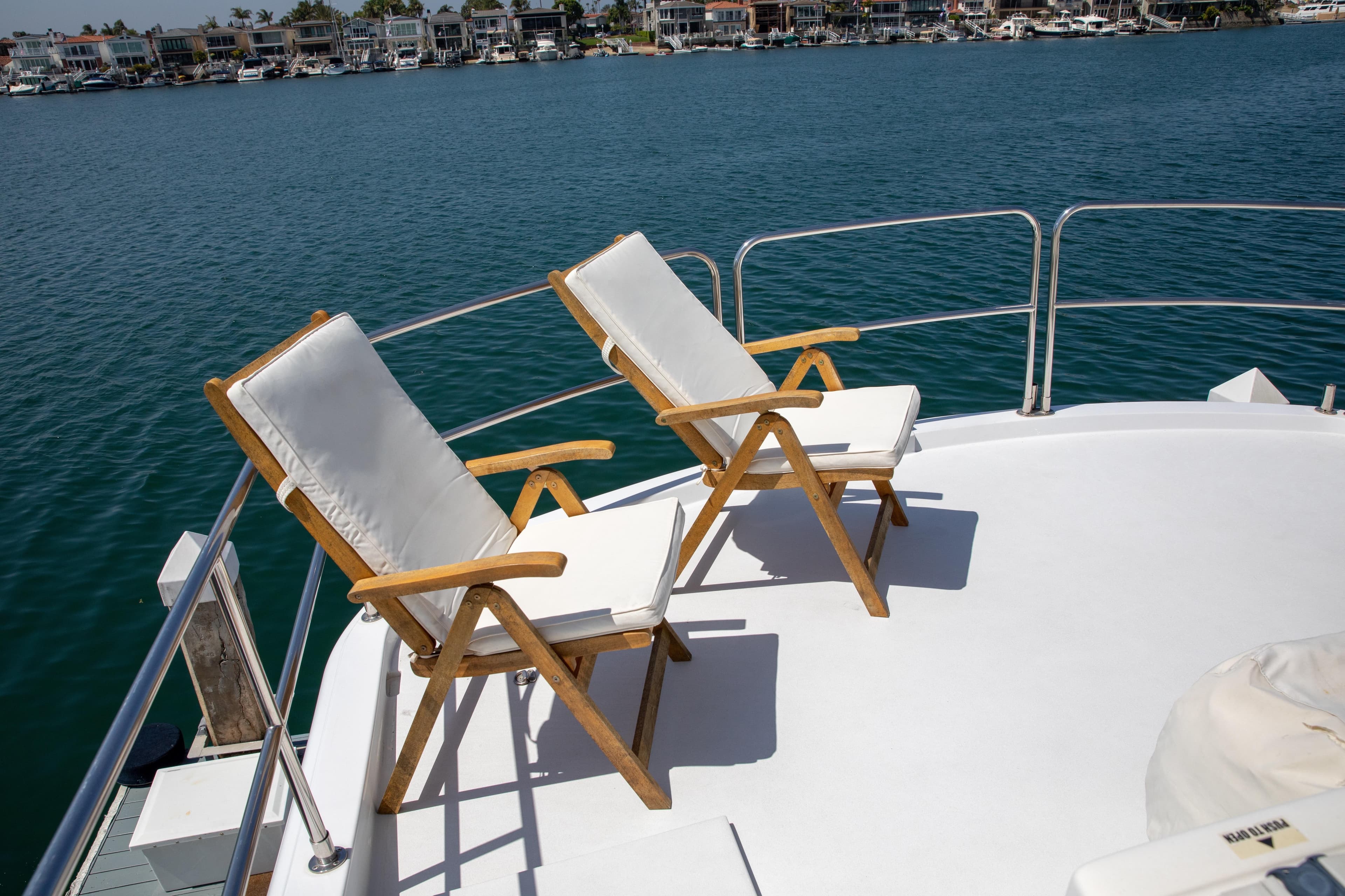 Two cushioned chairs on the deck of a 2002 Hatteras 63 Motor Yacht.