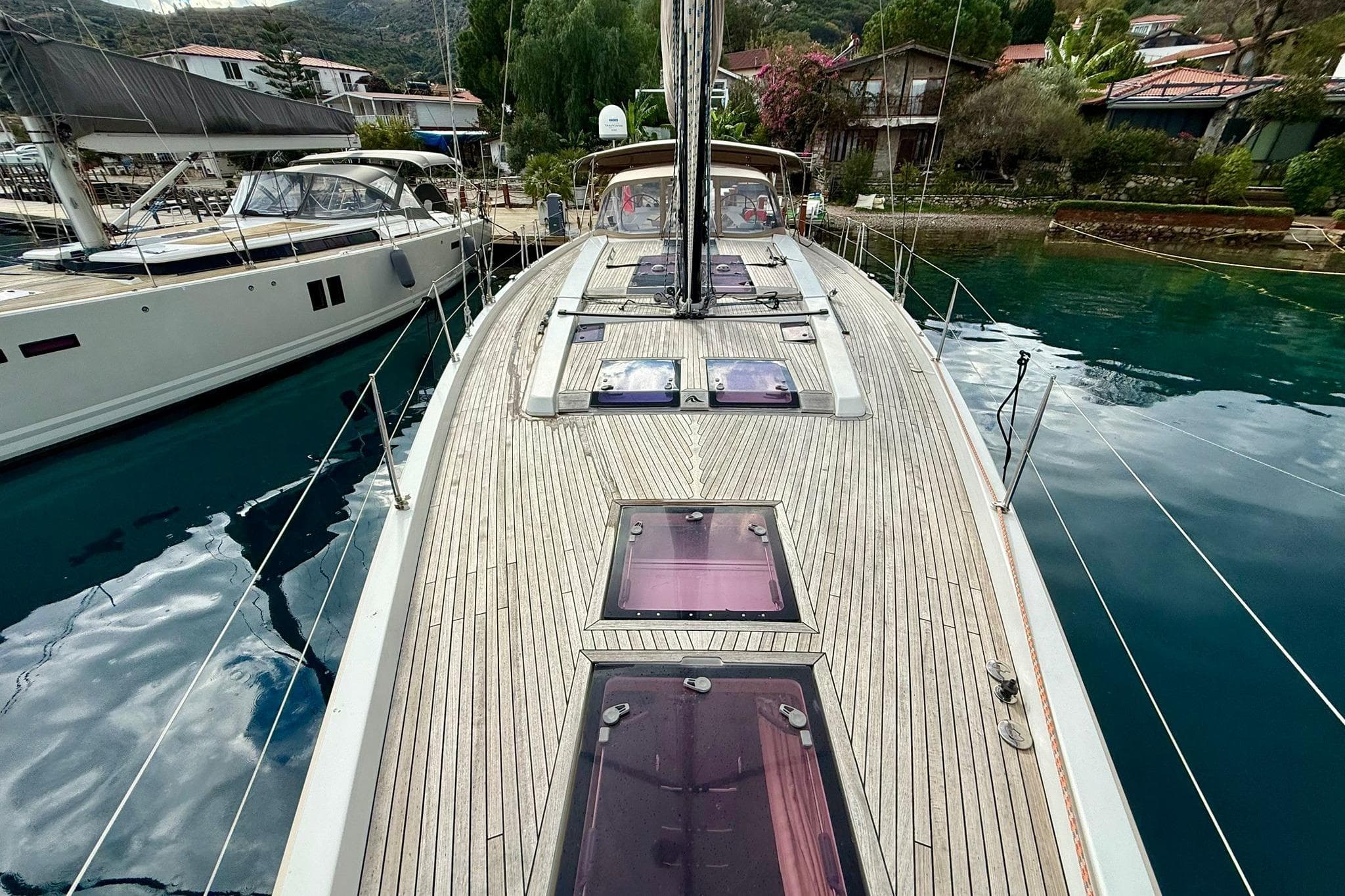Deck view of a 2012 Hanse 575 yacht docked in a serene marina.