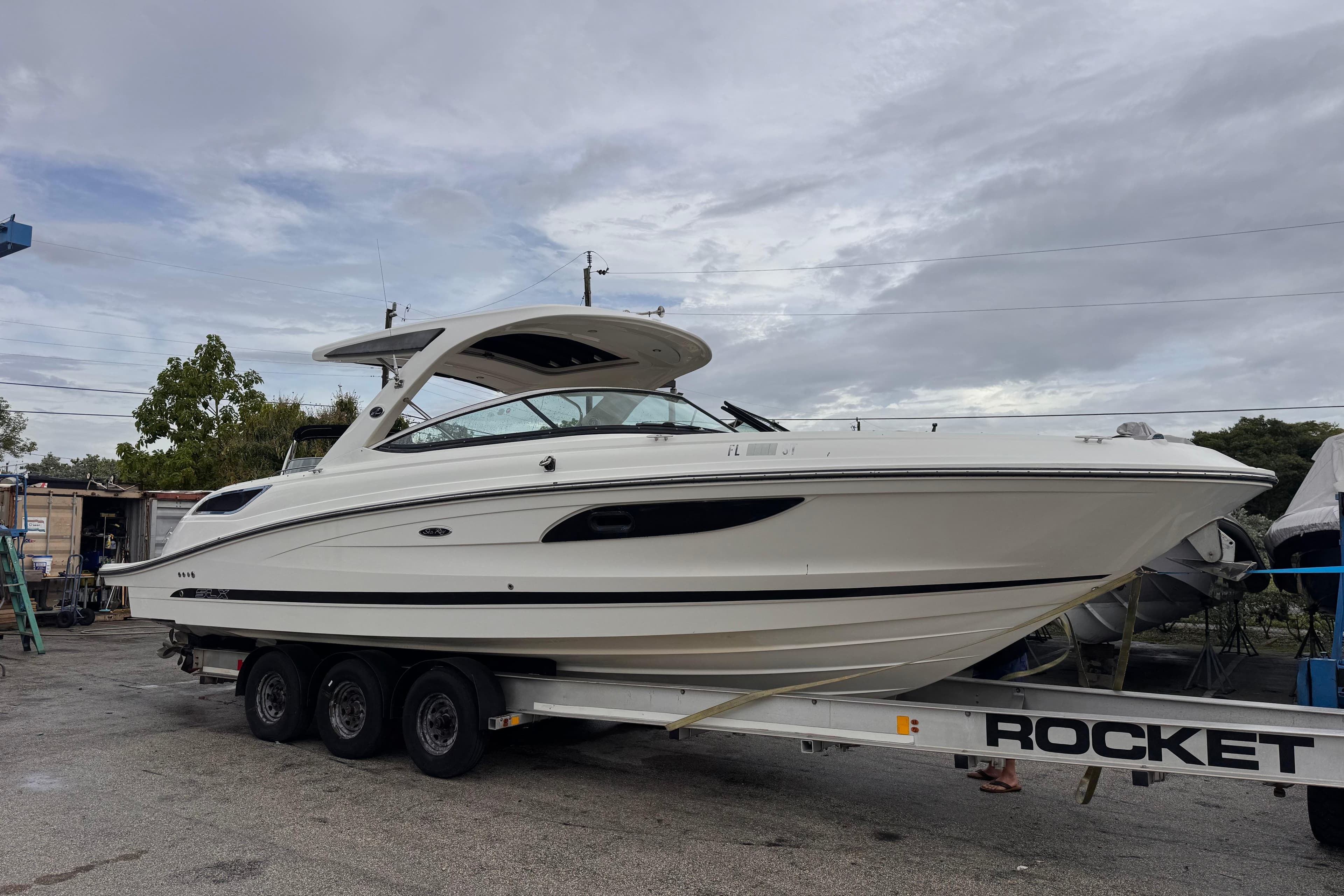 2016 Sea Ray SLX 350 boat on a trailer, parked outdoors under cloudy skies.
