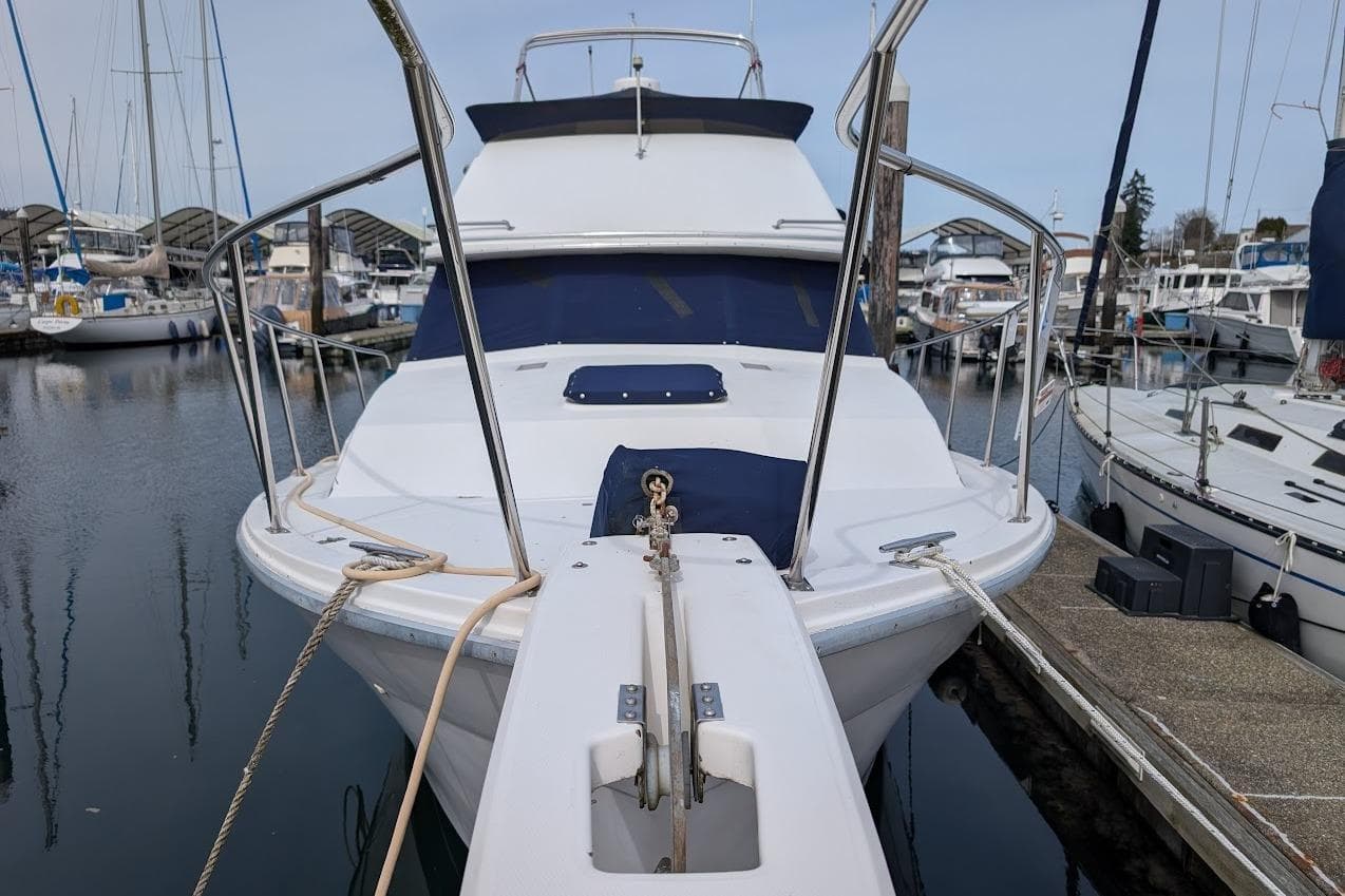 1986 Bayliner 3270 Motoryacht docked at marina, front view with ropes and railings.