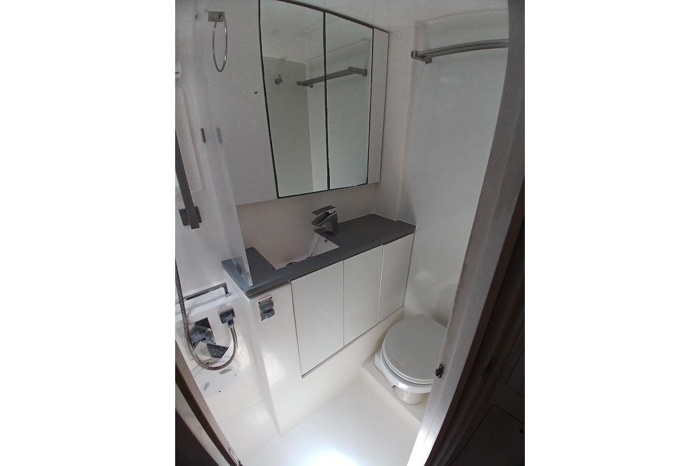 Compact bathroom in a 2020 Leopard 45 yacht, featuring modern fixtures and mirrored cabinets.