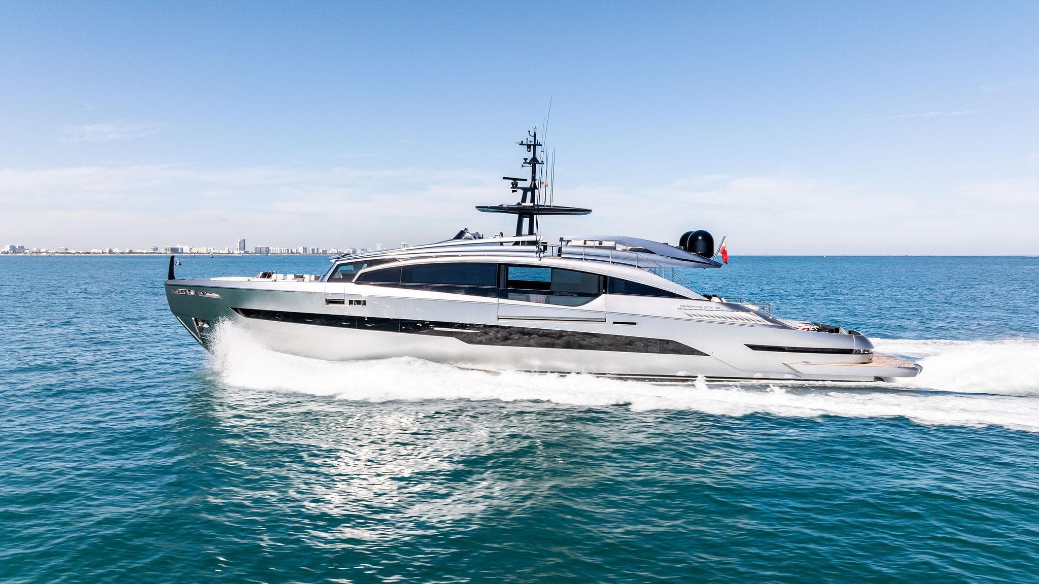 2023 Pershing GTX 116 yacht cruising on open sea under clear blue sky.